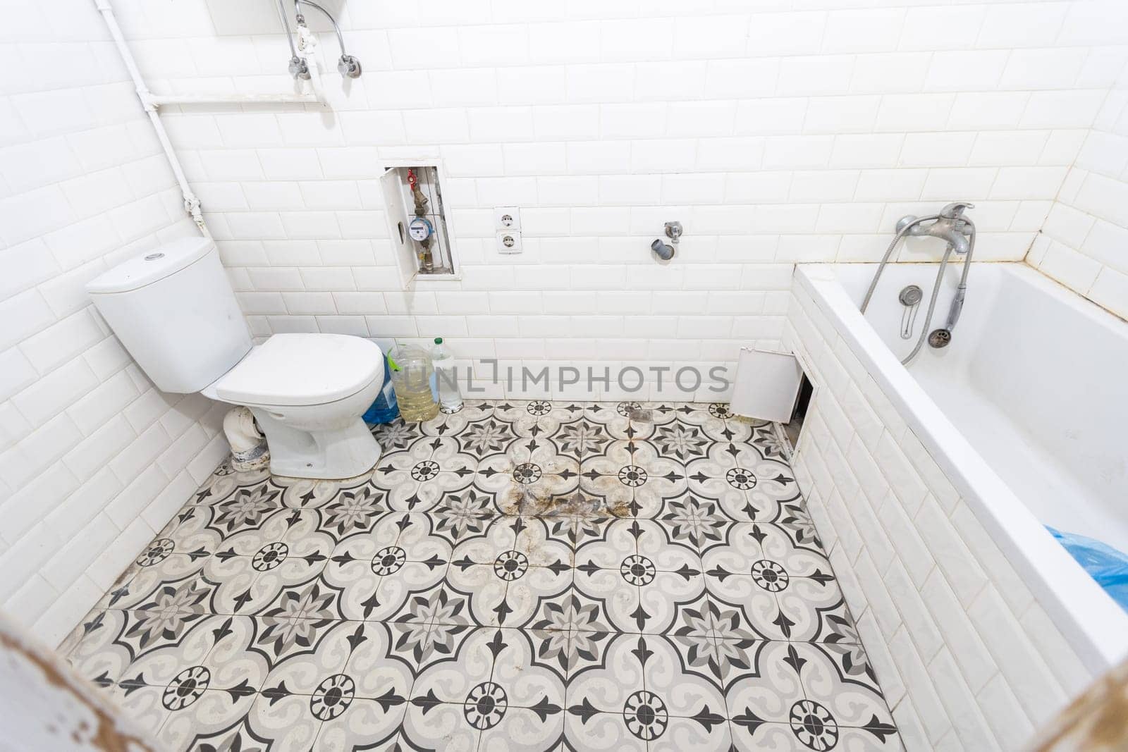 Interior of narrow restroom with wall hung toilet with white walls and checkered floor by Andelov13