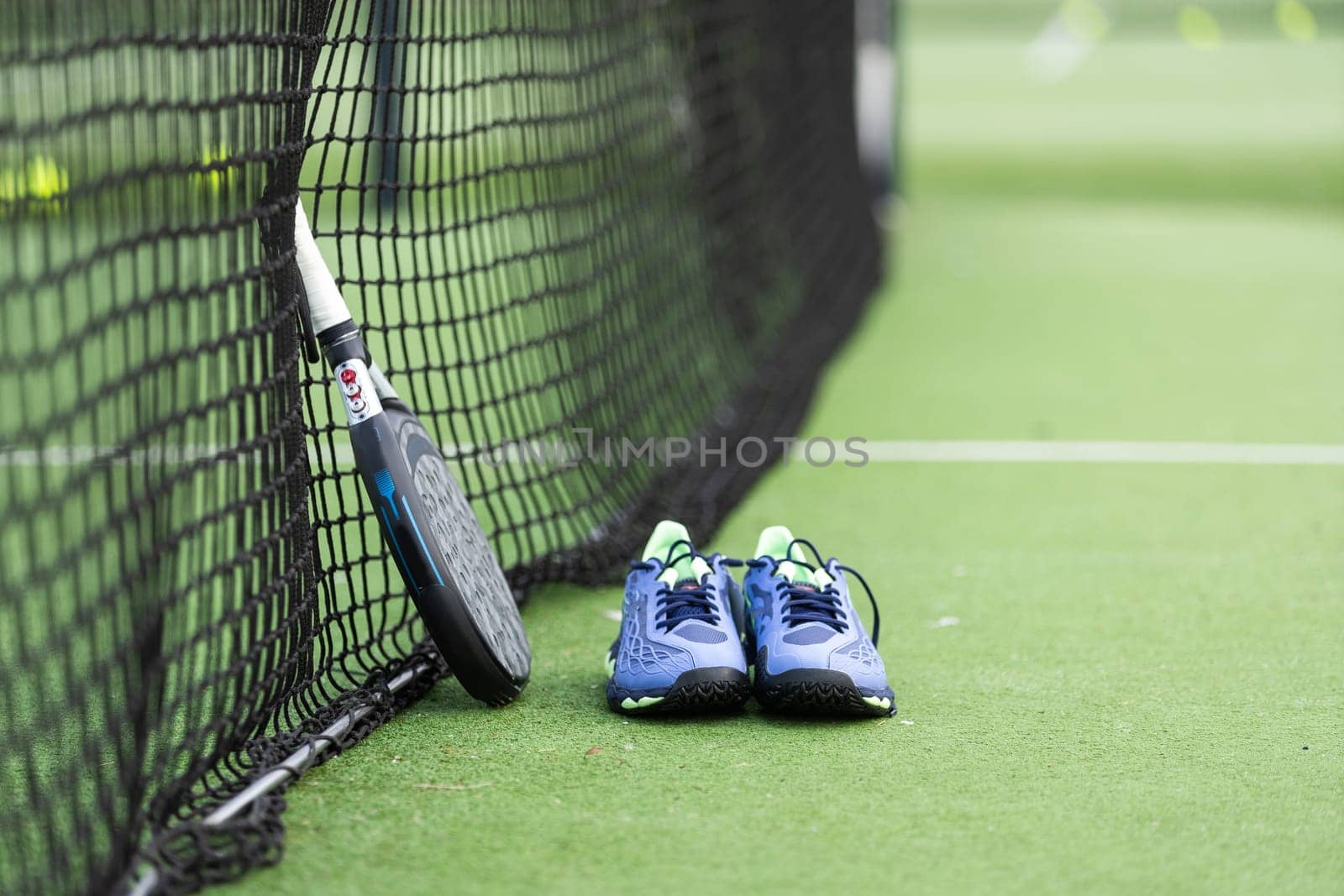 professional paddle tennis racket with natural lighting on blue background. Horizontal sport theme poster, greeting cards, headers, website and app. High quality photo