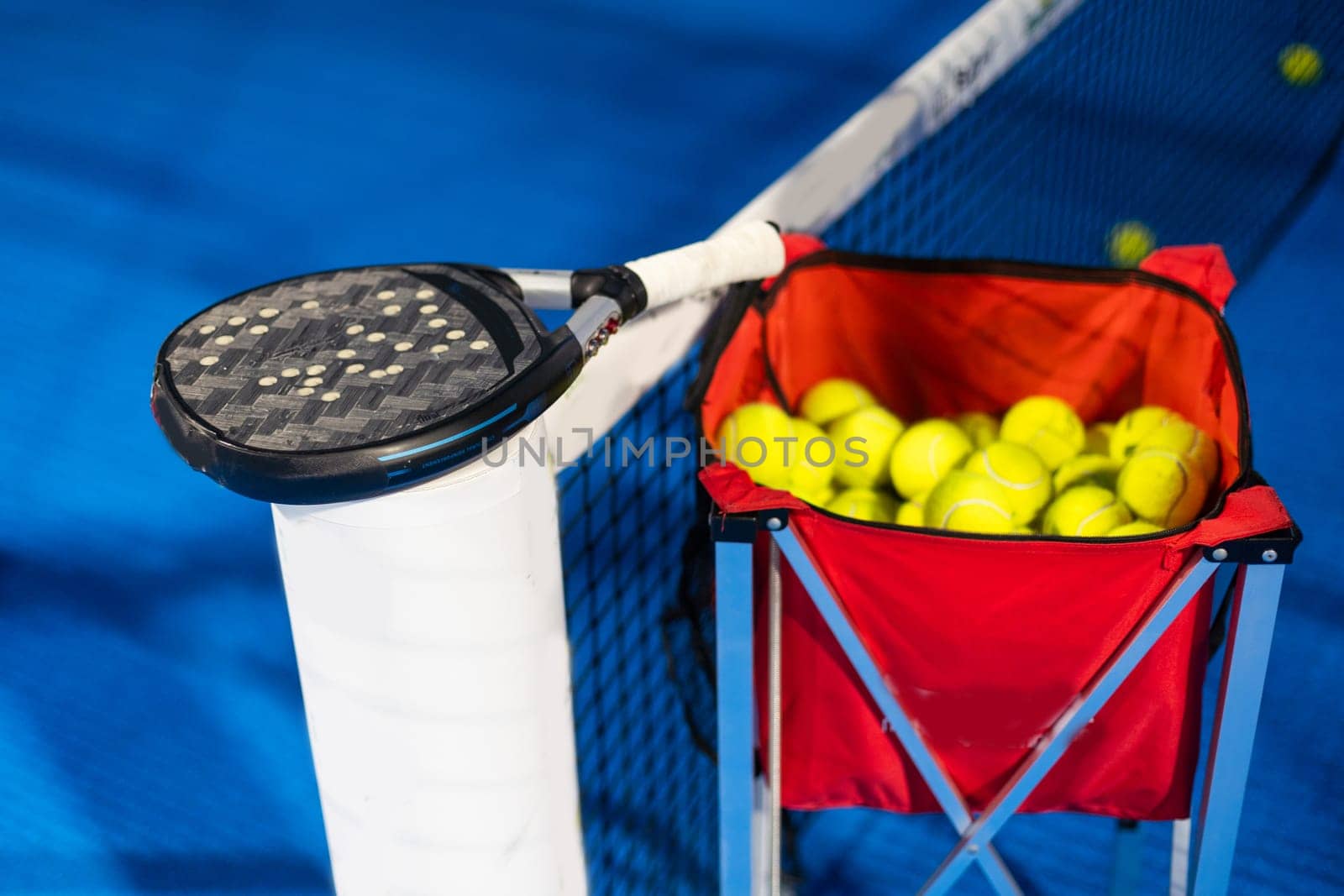 paddle tennis racket and balls on the blue paddle court by Andelov13