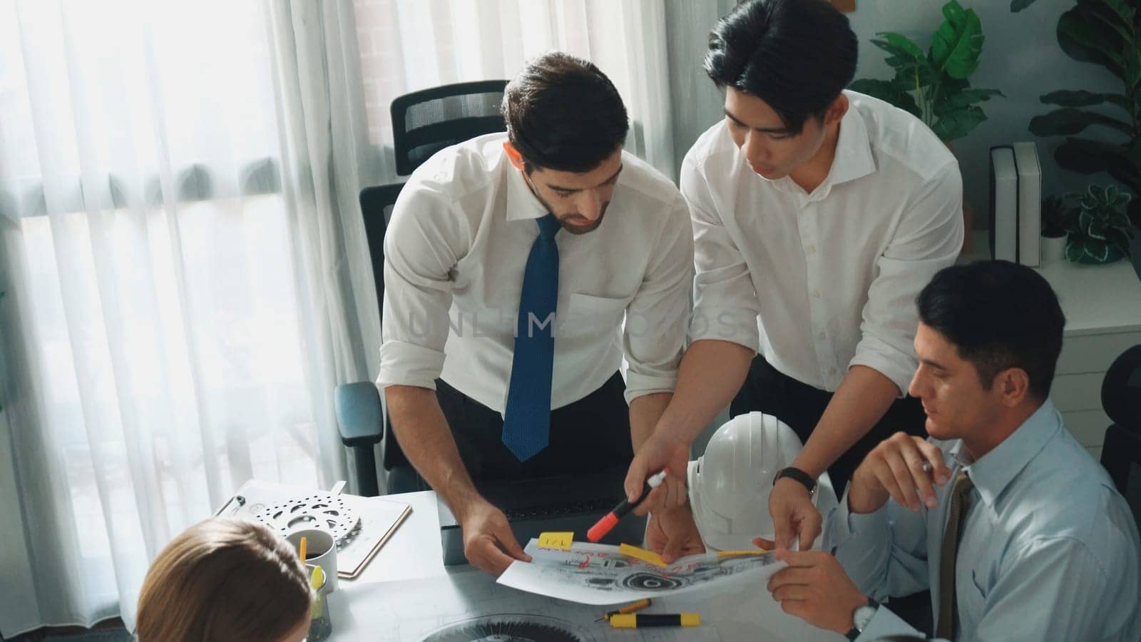 Top view of engineer pointing at turbine engine at meeting table with equipment. Aerial view of professional project manager talking and discussing about electronic generator system. Alimentation.