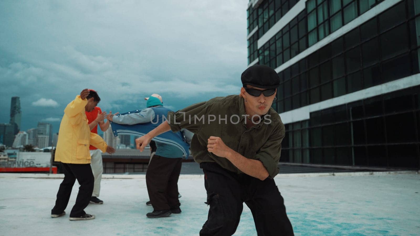 Professional asian dancer practice B boy dance while multicultural friends dancing at roof top. Young modern dancing group doing hip hop movement. Style,fashion,action. Outdoor sport 2024. Endeavor.