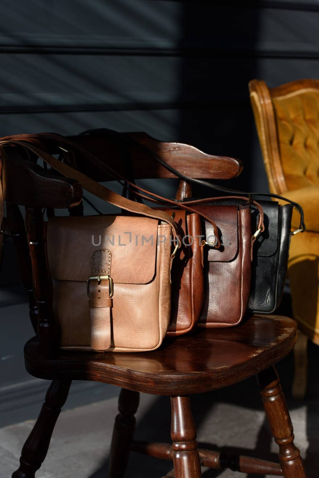 close-up photo of colorful messanger leather bags on a wooden chair by Ashtray25