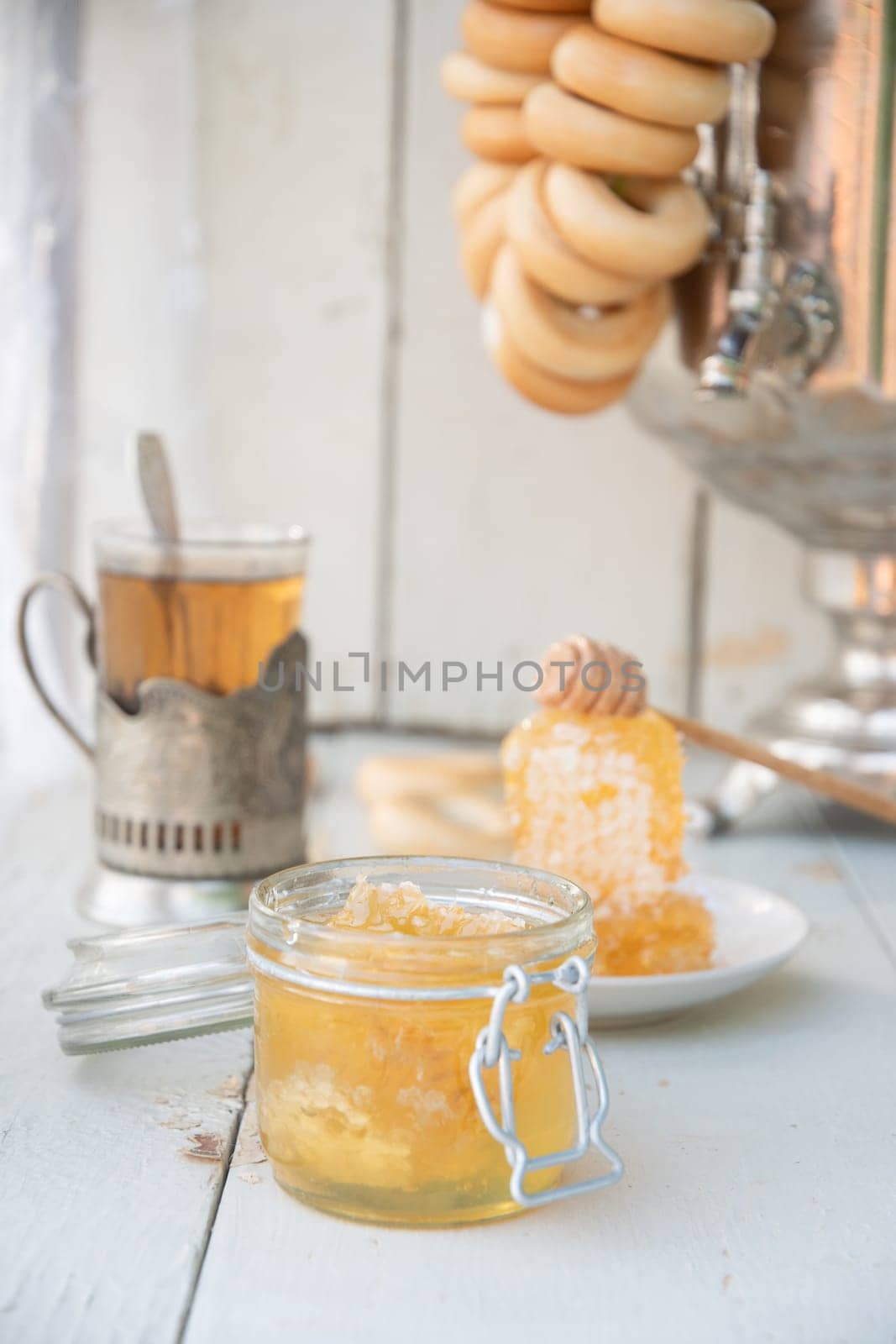 honeycomb with honey in a jar and tea from a Russian samovar with bagels, Slavic tea drinking, organic vitamin product as alternative medicine, high quality photo