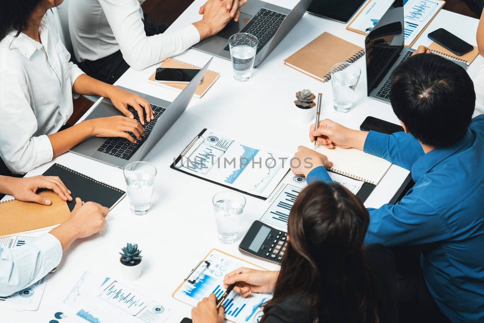 Analyst team utilizing BI Fintech to analyze financial data at table in meeting room. Businesspeople analyzing BI dashboard power on paper for business insight and strategic marketing planning.Prudent