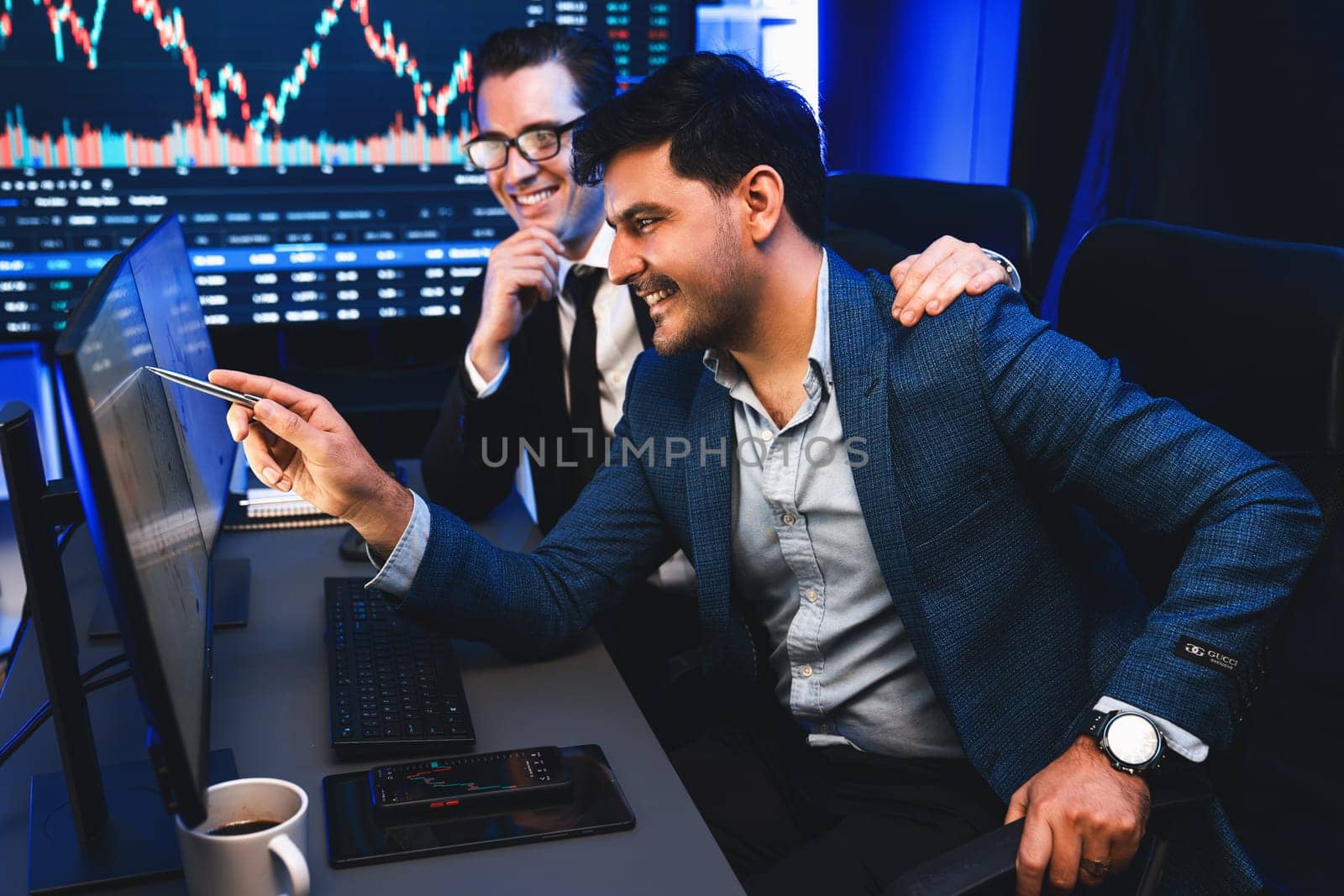 Two stock exchange traders getting profit in trading currency stock. Successful stock exchange showing financial benefit data on monitor screen at highest point of neon light at workplace. Sellable.