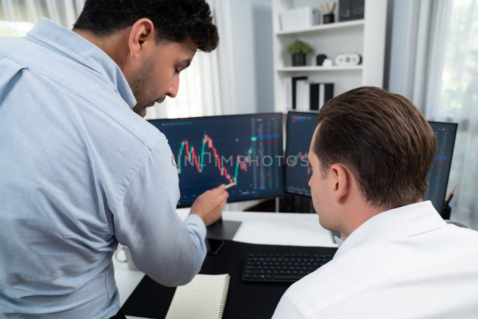 Stock exchange traders discussing digital currency or market online focusing on real time dynamic data with two screen, analyzing increased possible trend investment at modern workplace. Sellable.