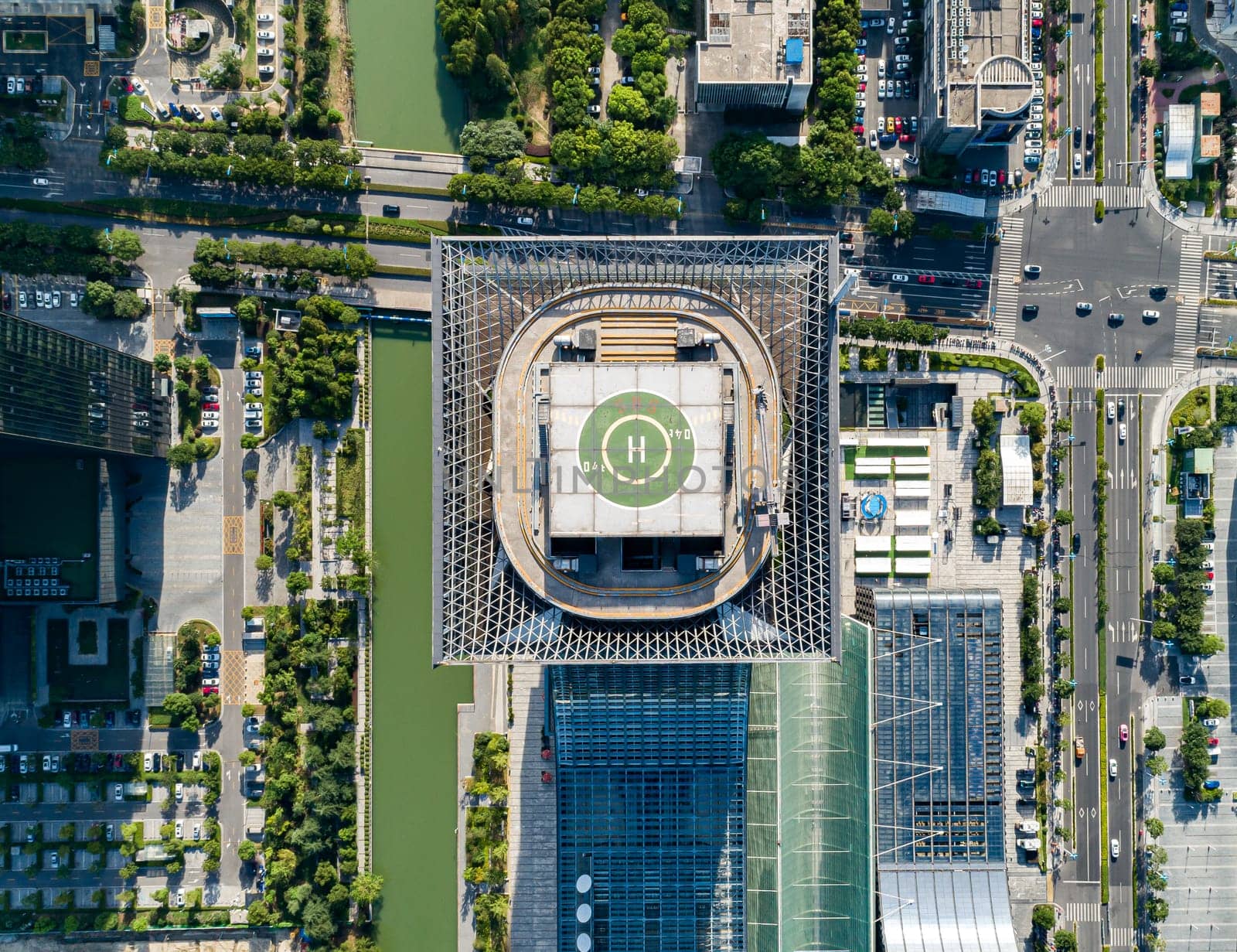 Aerial drone view of helipad on the roof of a skyscraper in downtown.