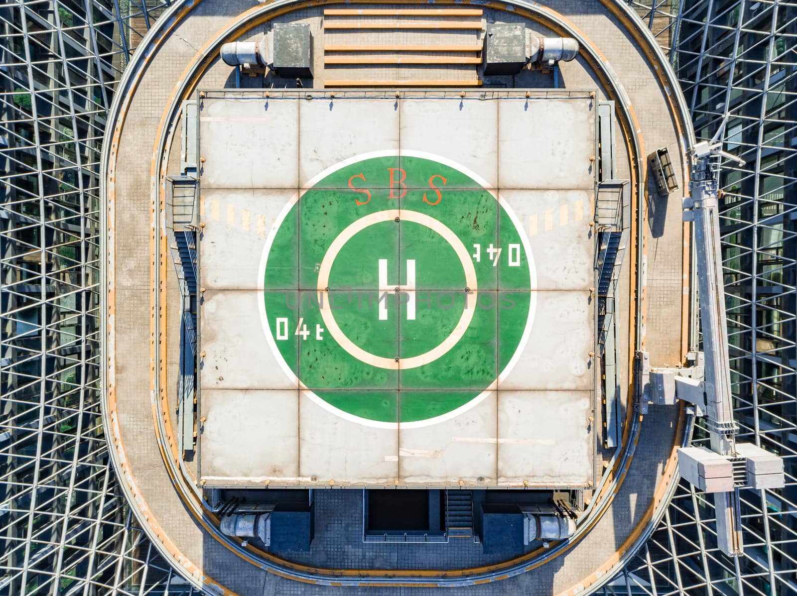 Helipad on the rooftop of the modern skyscraper. Glass business offices district. Aerial drone view of helipad on the roof of a skyscraper in downtown. by Busker