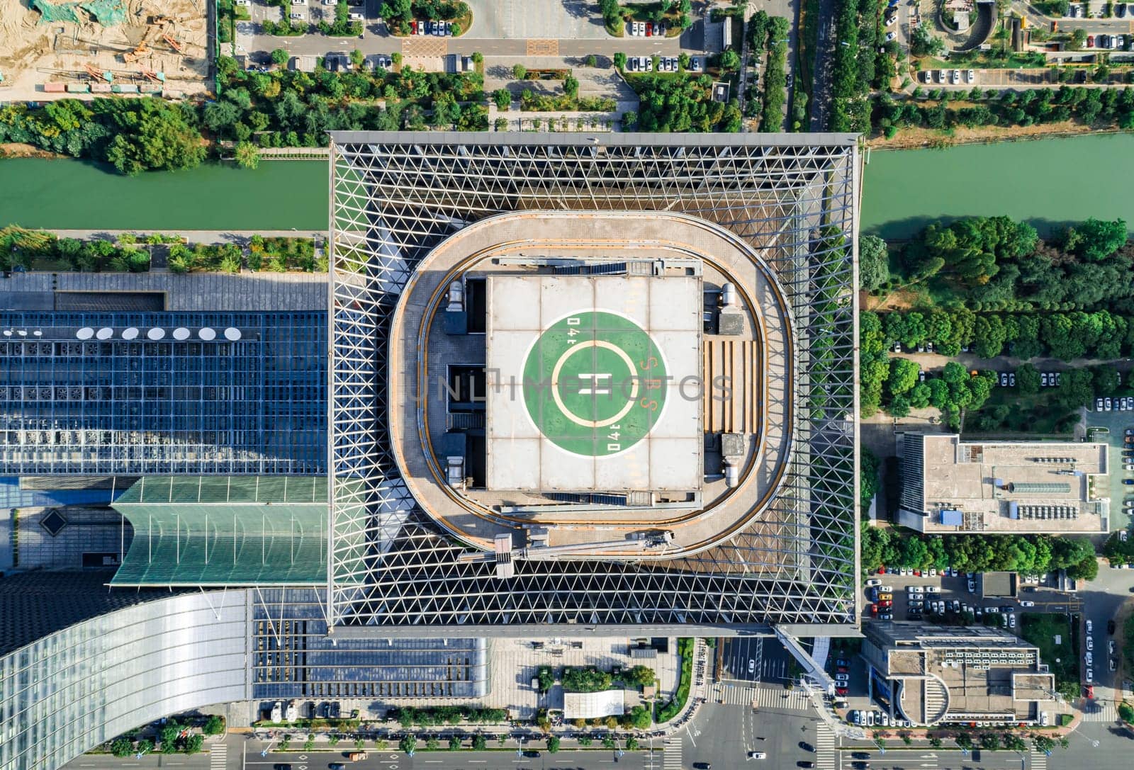 Helipad on the rooftop of the modern skyscraper. Glass business offices district. Aerial drone view of helipad on the roof of a skyscraper in downtown. by Busker