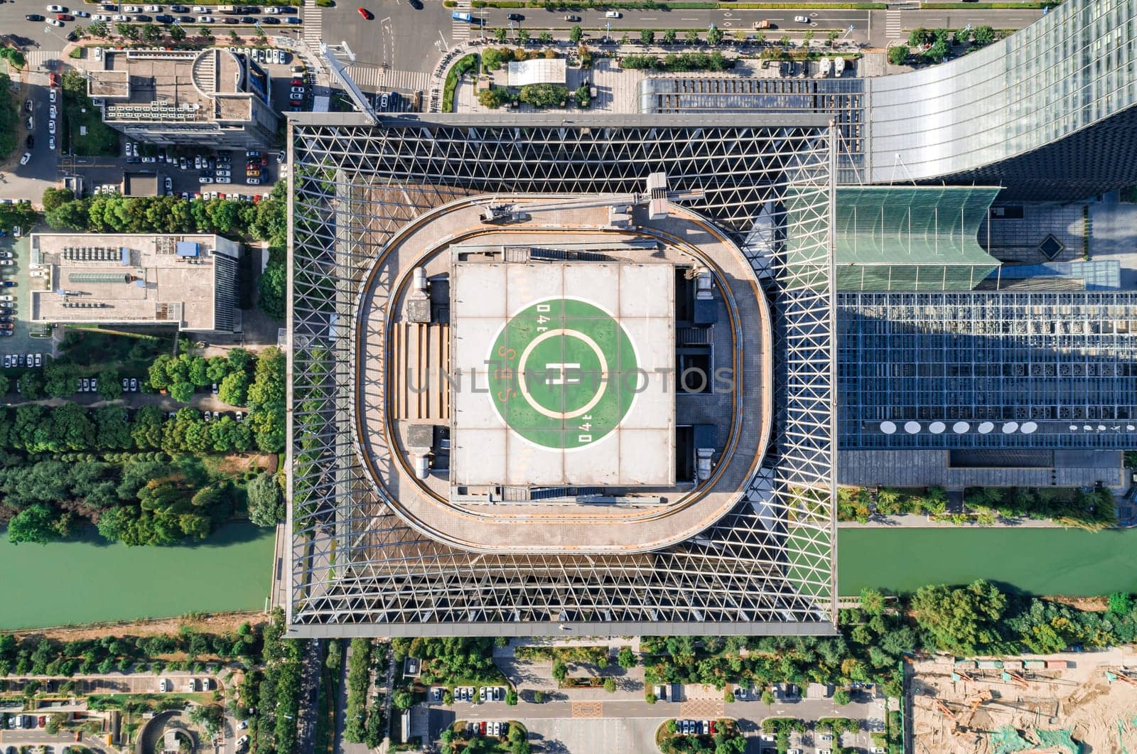 Aerial drone view of helipad on the roof of a skyscraper in downtown.