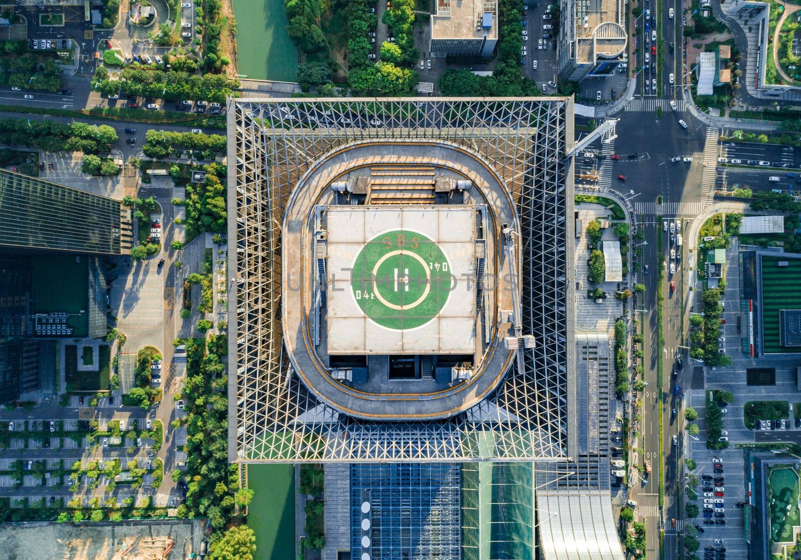 Aerial drone view of helipad on the roof of a skyscraper in downtown.