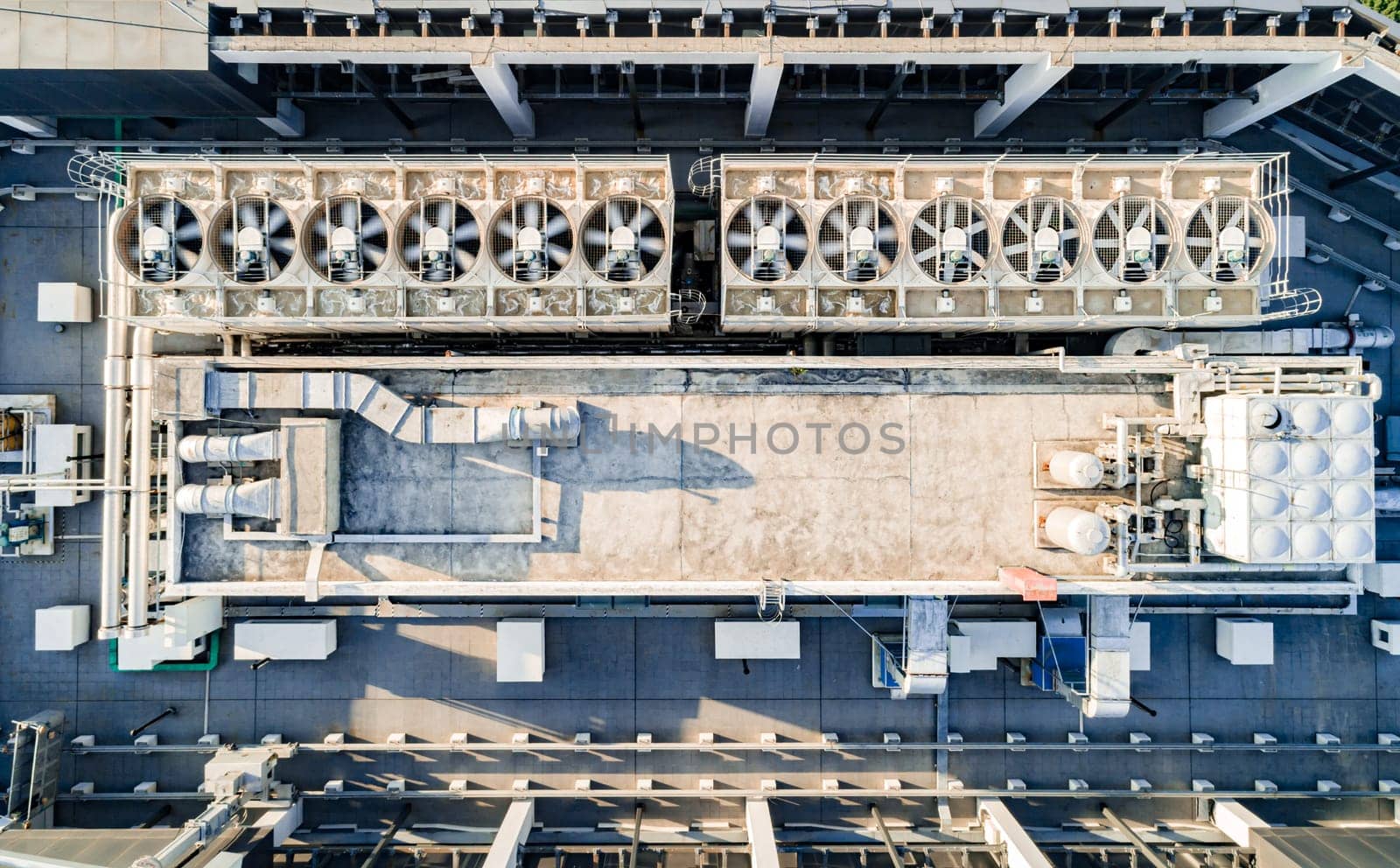 Aerial top down view of ventilation and air conditioning systems installed on the rooftop of a skyscraper in a developed business district by Busker