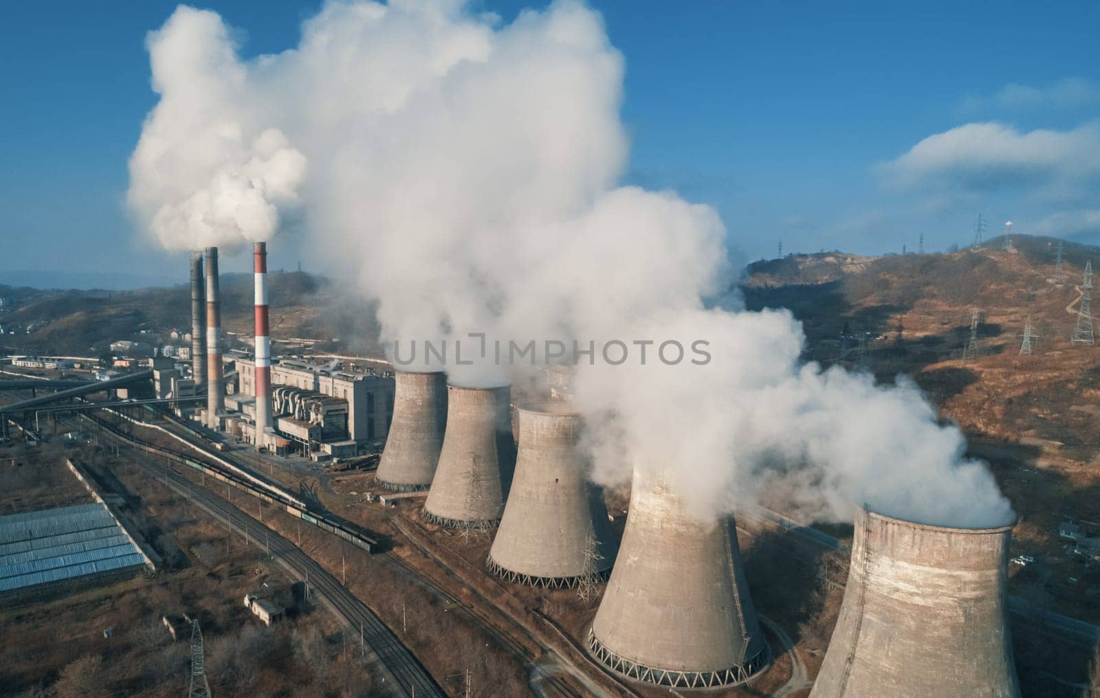 Aerial view of an industrial zone pipes pouring thick white smoke. Thick smoke plumes. Thermal power plant pipes, air pollution. by Busker