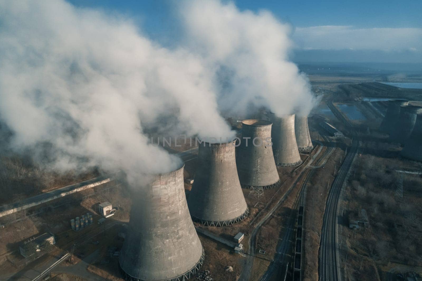 Aerial view of an industrial zone pipes pouring thick white smoke. Thick smoke plumes. Thermal power plant pipes, air pollution.