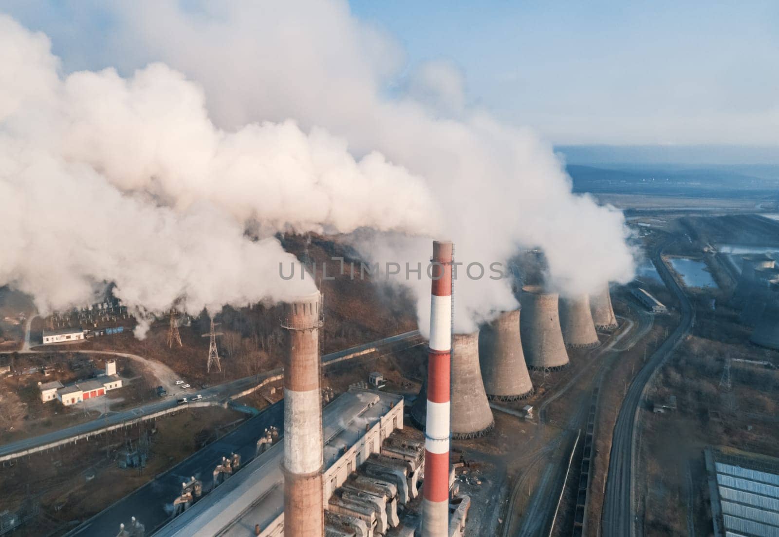 Aerial view of smoking pipes and cooling towers of coal thermal power plant