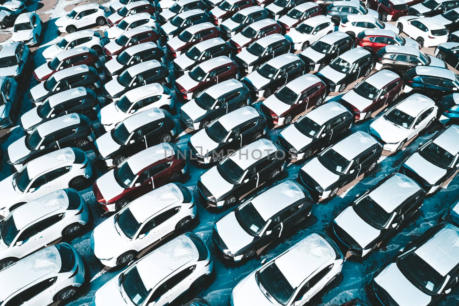 Aerial view of new cars parked in car parking lot. Car dealer parking lot full of new automobiles. New cars lined up for import and export business.