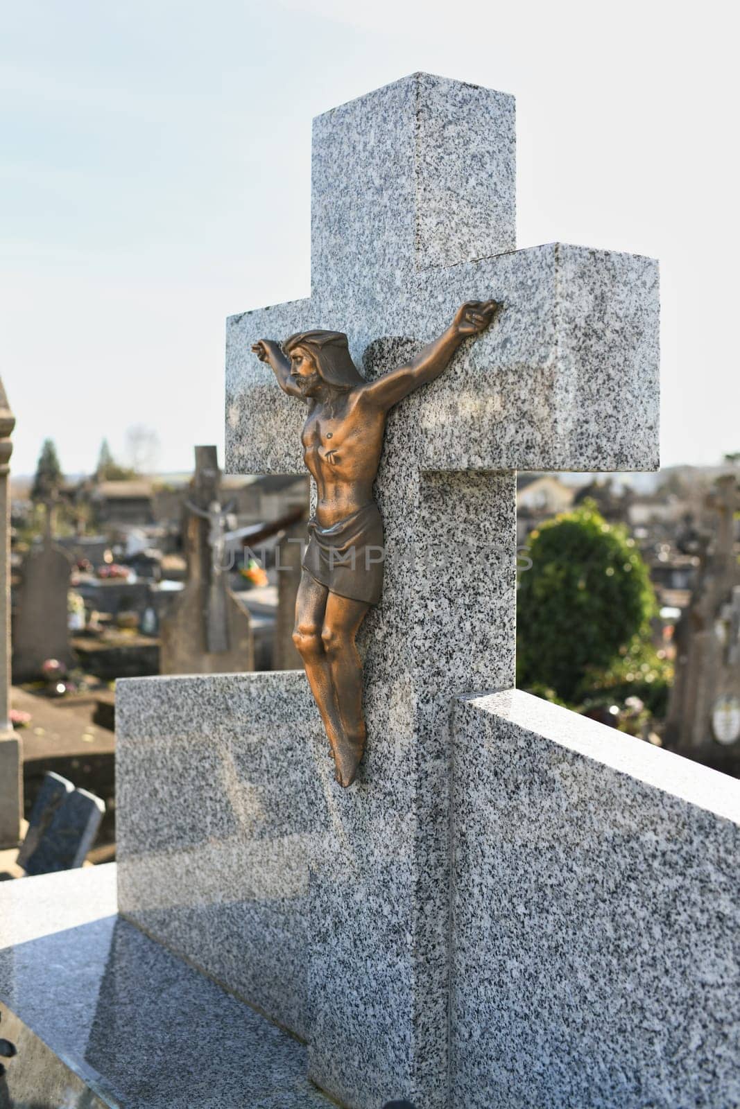 Crucified Jesus Christ on a cross on a grave in a cemetery by Godi
