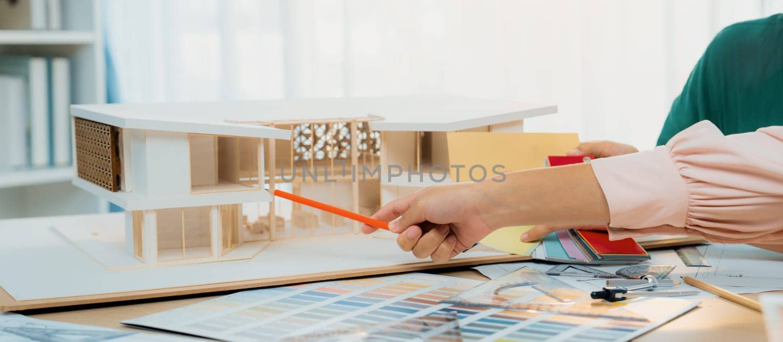 Professional architect team discussing about house design and appropriate interior materials. Cropped image of interior designers brainstorming about interior materials at meeting room. Variegated.