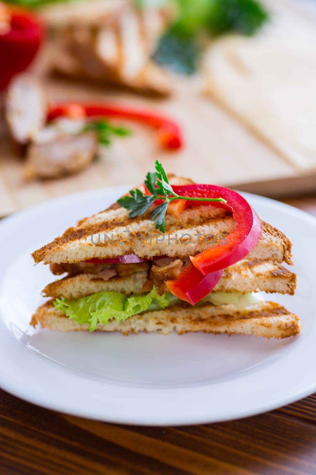 fried toast with chicken, salad, greens on a wooden table .