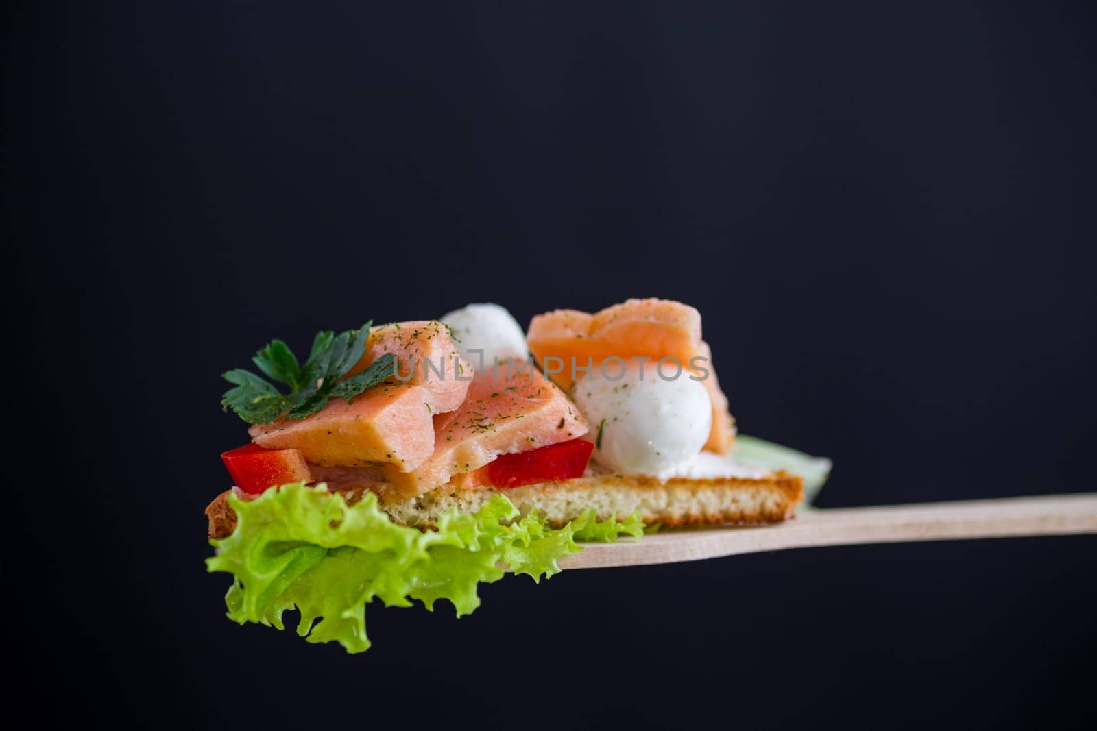 fried toast with salmon, cream cheese, salad, isolated on black background .