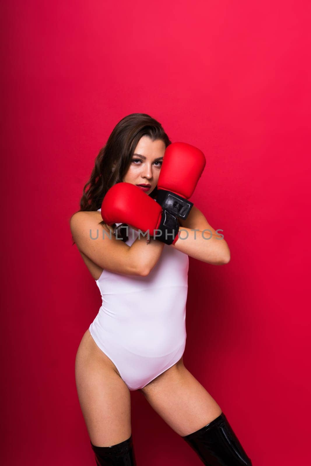 Attractive young brunette woman in boxers gloves, studio shot by Zelenin