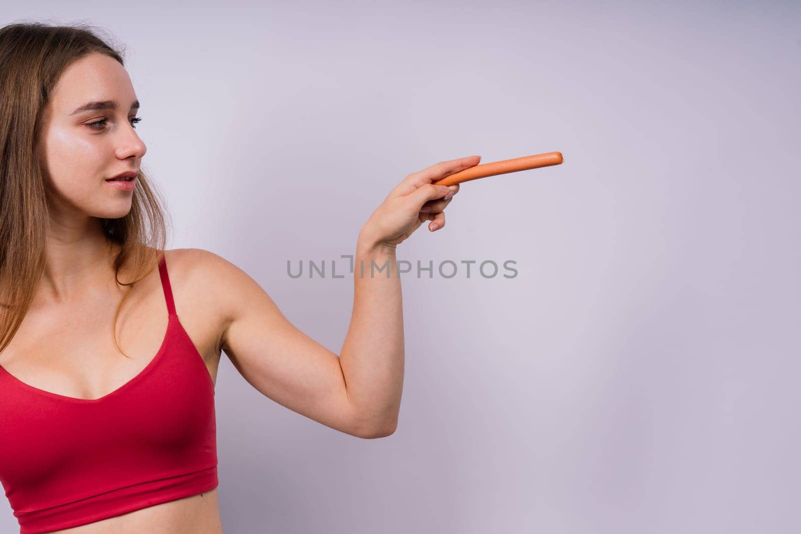 Close-up of woman eating a sausage. Cropped photo in studio