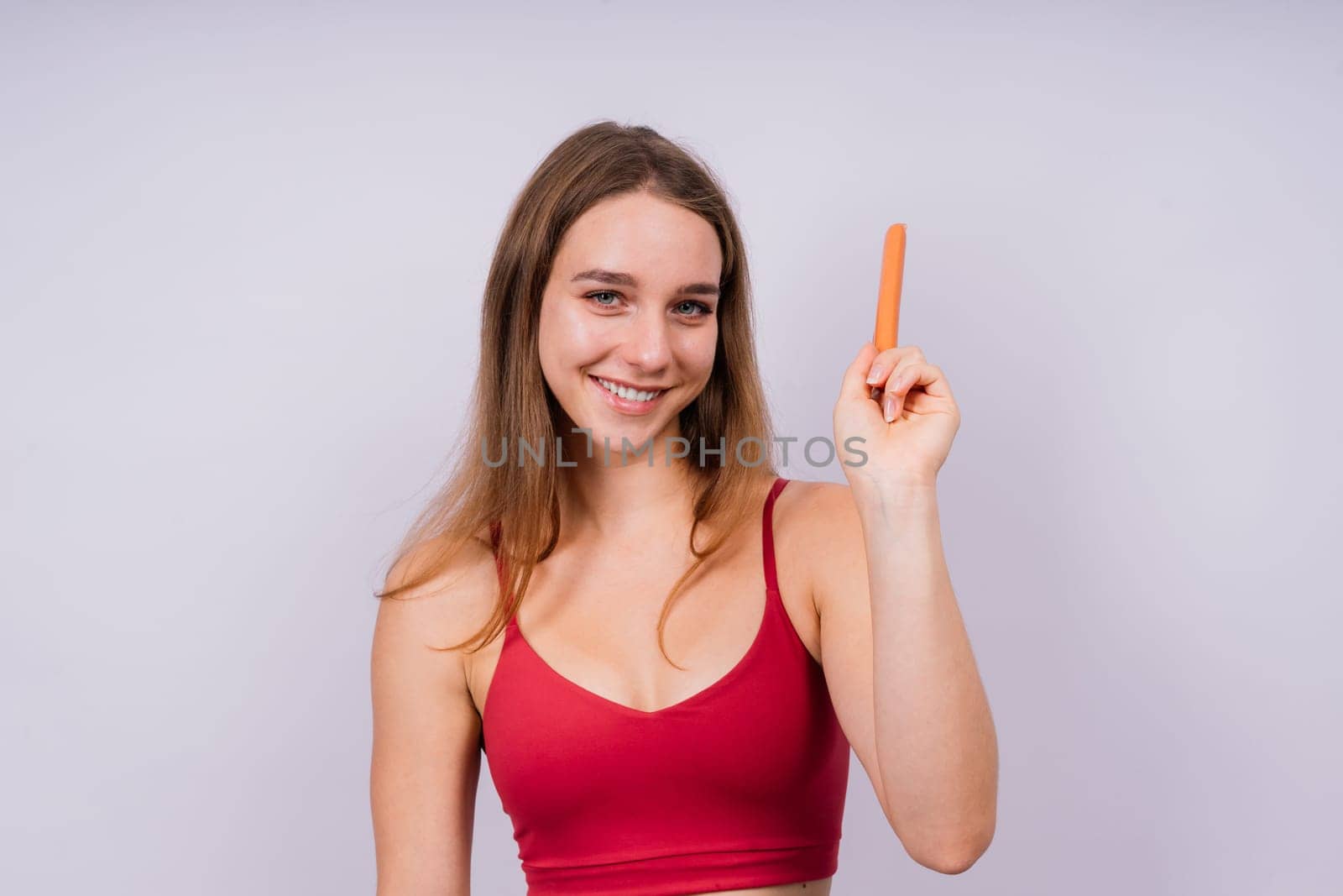 Close-up of a woman eating a sausage. Cropped photo in studio by Zelenin