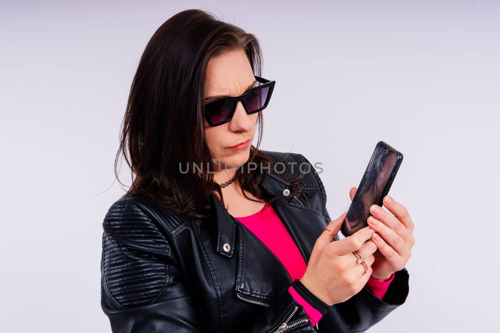 A frustrated young woman with a broken phone in her hands. White isolated background. Broken Gadget by Zelenin