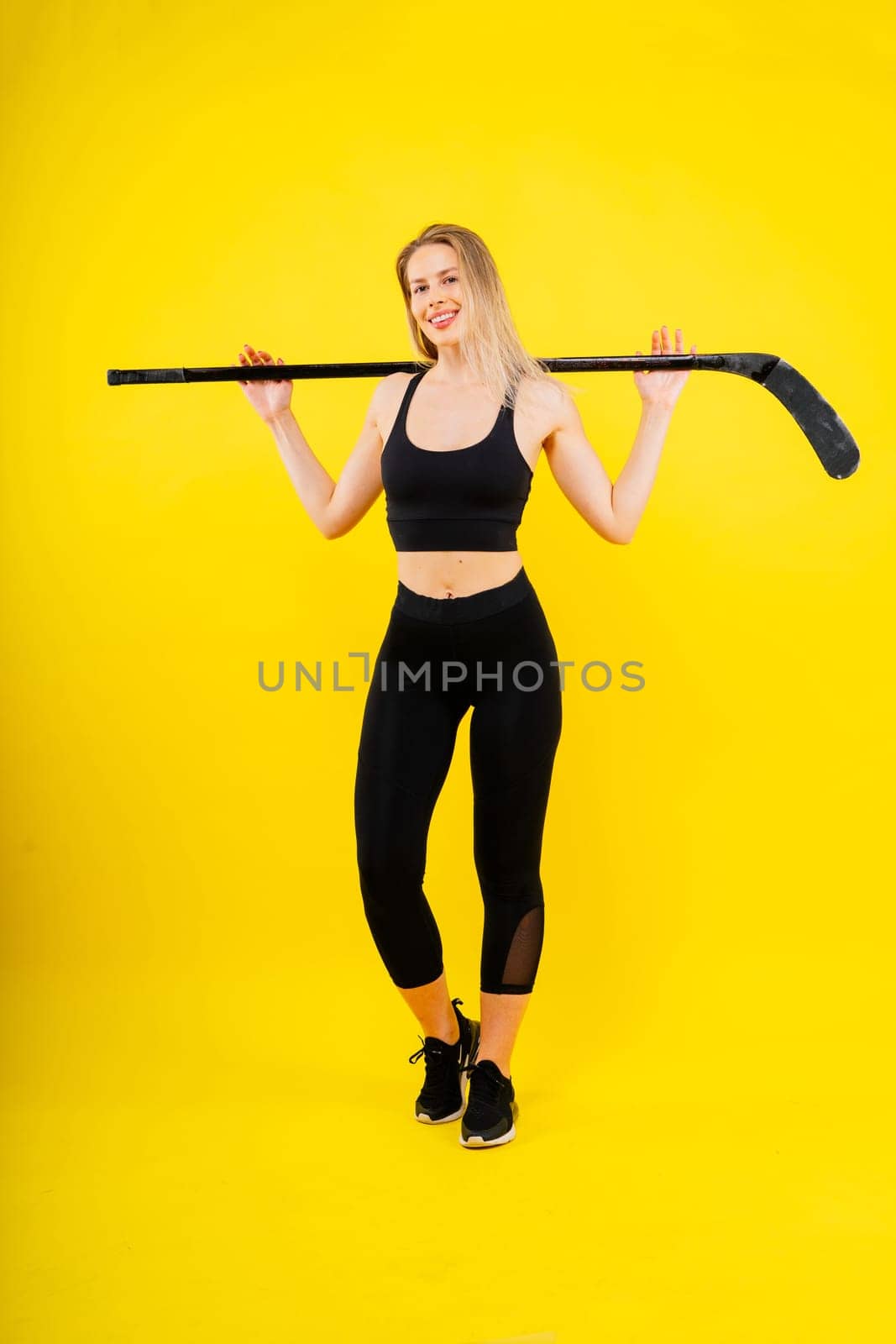 Luxuriously dressed female with hockey stick. Women's winter sports.