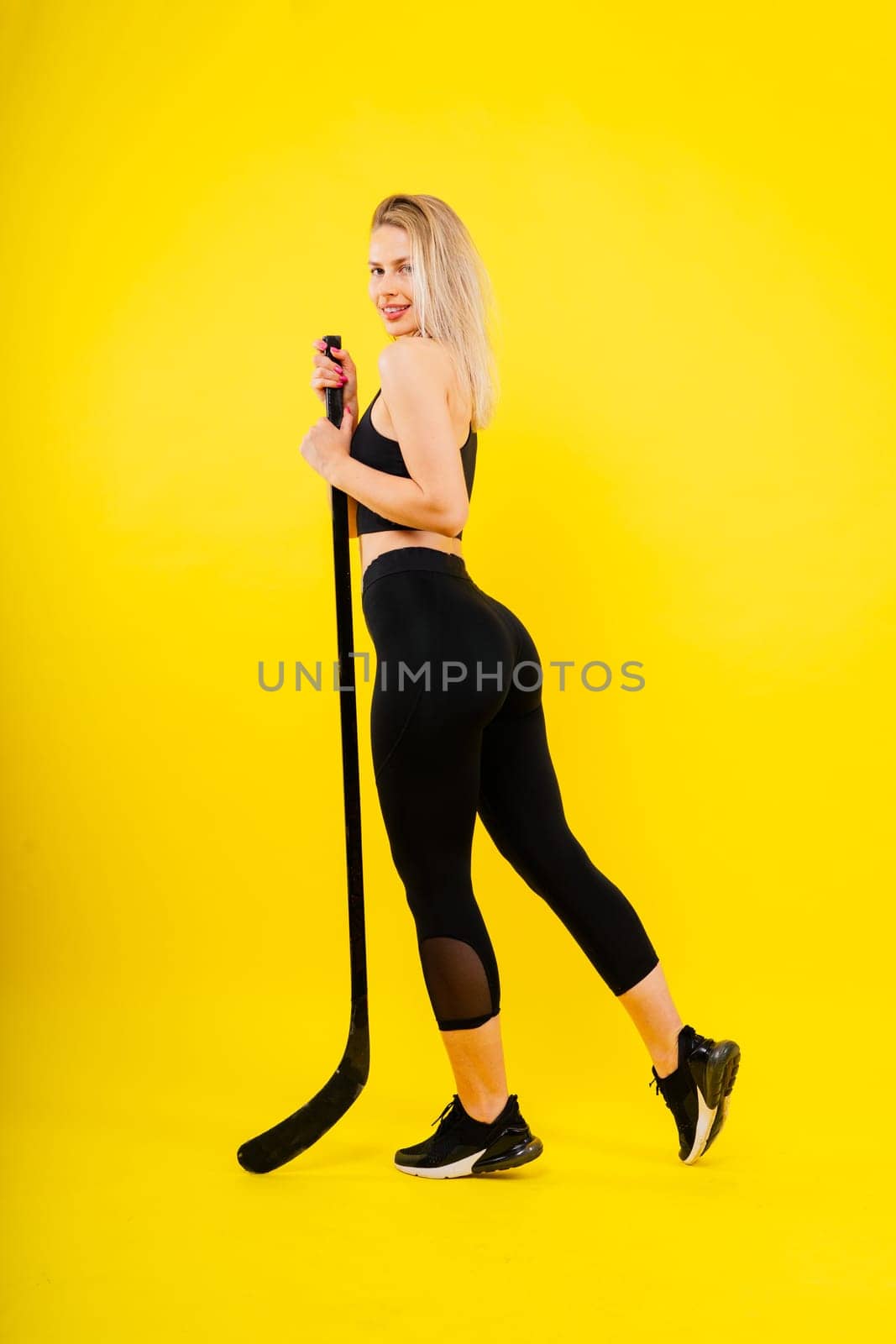 Luxuriously dressed female with hockey stick. Women's winter sports.