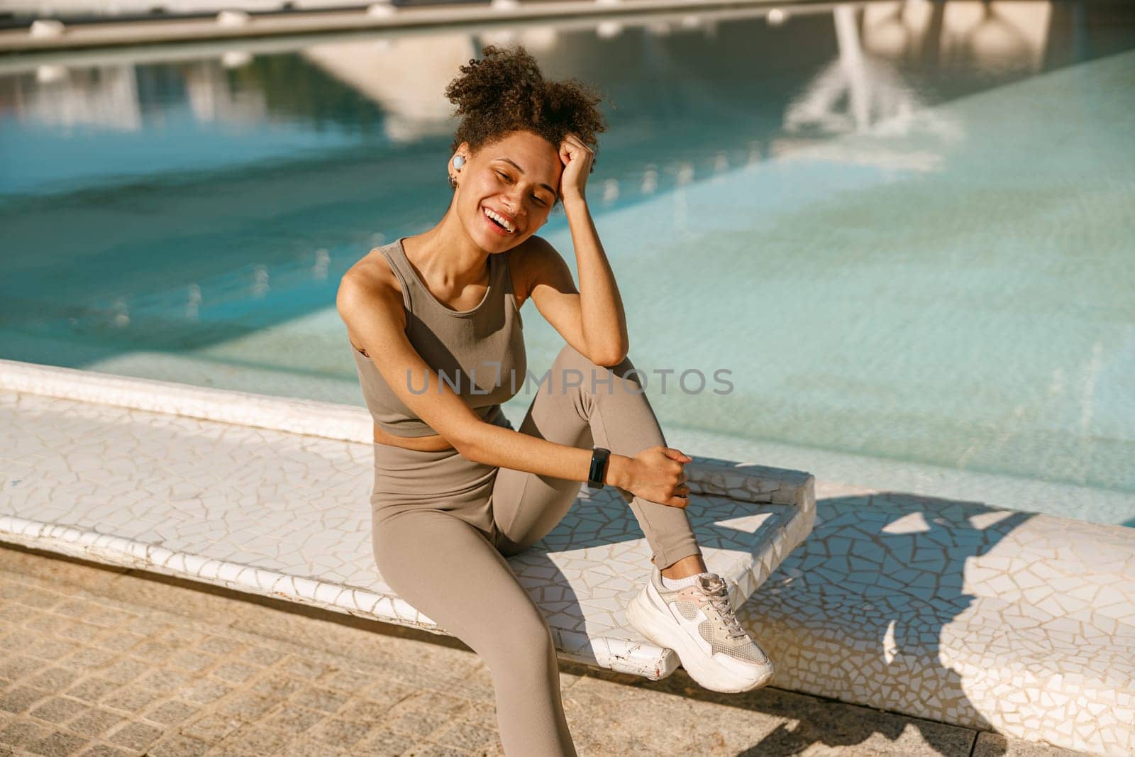 Young female athlete in sportswear have a rest after morning jogging outside and looks camera by Yaroslav_astakhov
