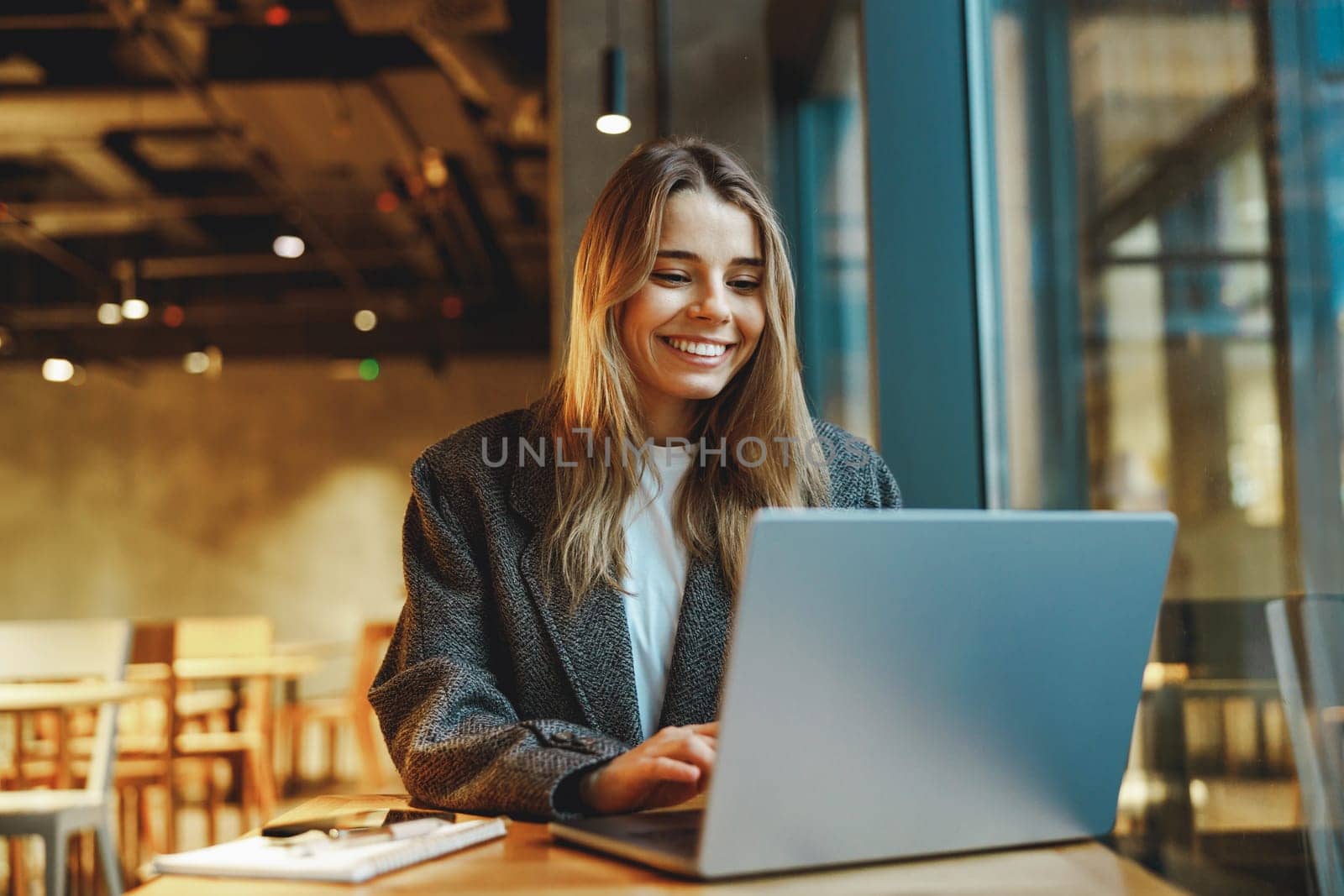 Stylish woman manager freelancer working on laptop while sitting in cozy cafe. High quality photo