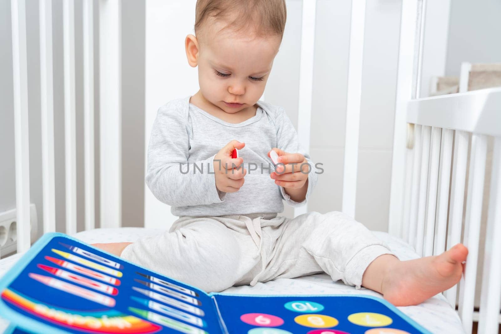 Baby Engaged with Montessori Busy Book in Crib by Mariakray