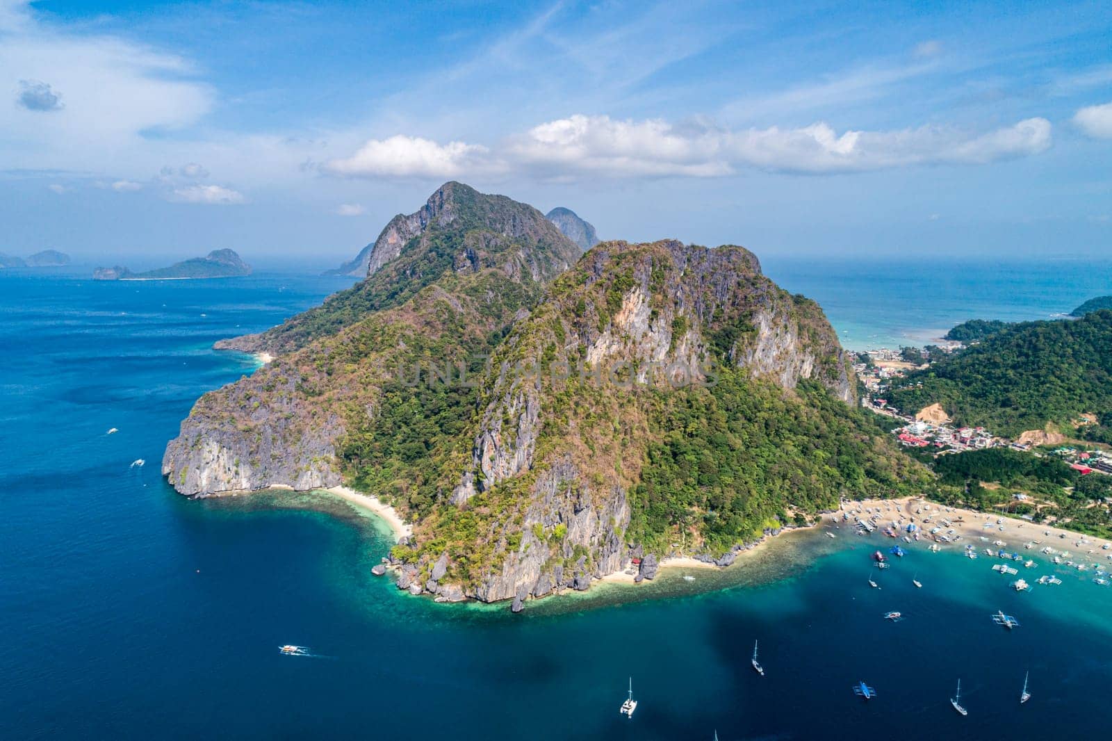 Aerial view of beach, sea and mountain on sunny day. El Nido, Palawan. Tropical landscape hill, mountains rocks with rainforest and azure water of lagoon. by Busker