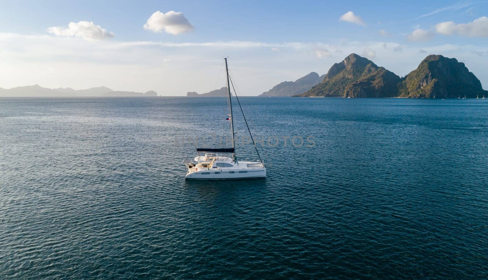 Aerial drone view of sailing yacht anchored in the bay with clear and turquoise water. Sailing yachtin the tropical lagoon.