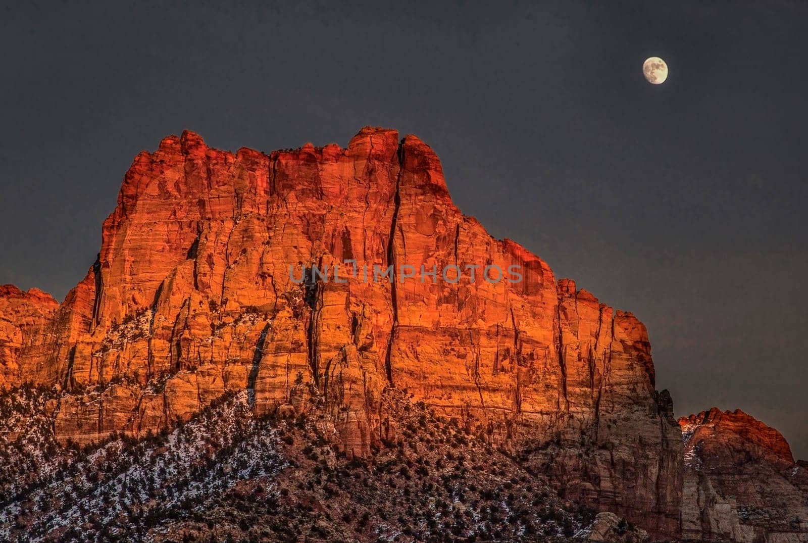 A bright rising moon makes an appearance at Zion National Park, Utah