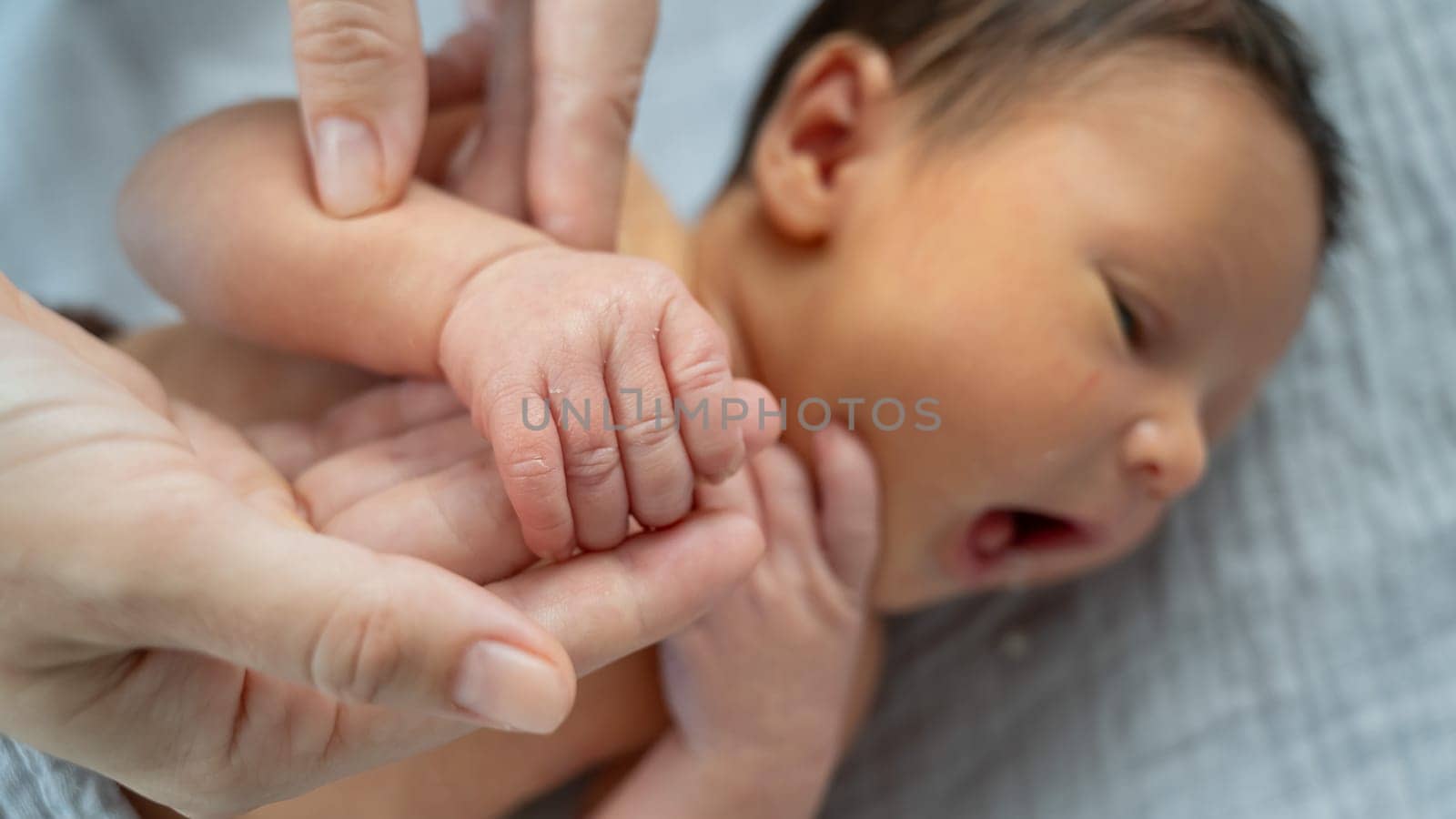 A newborn boy holds his mother's finger. Close-up of hands