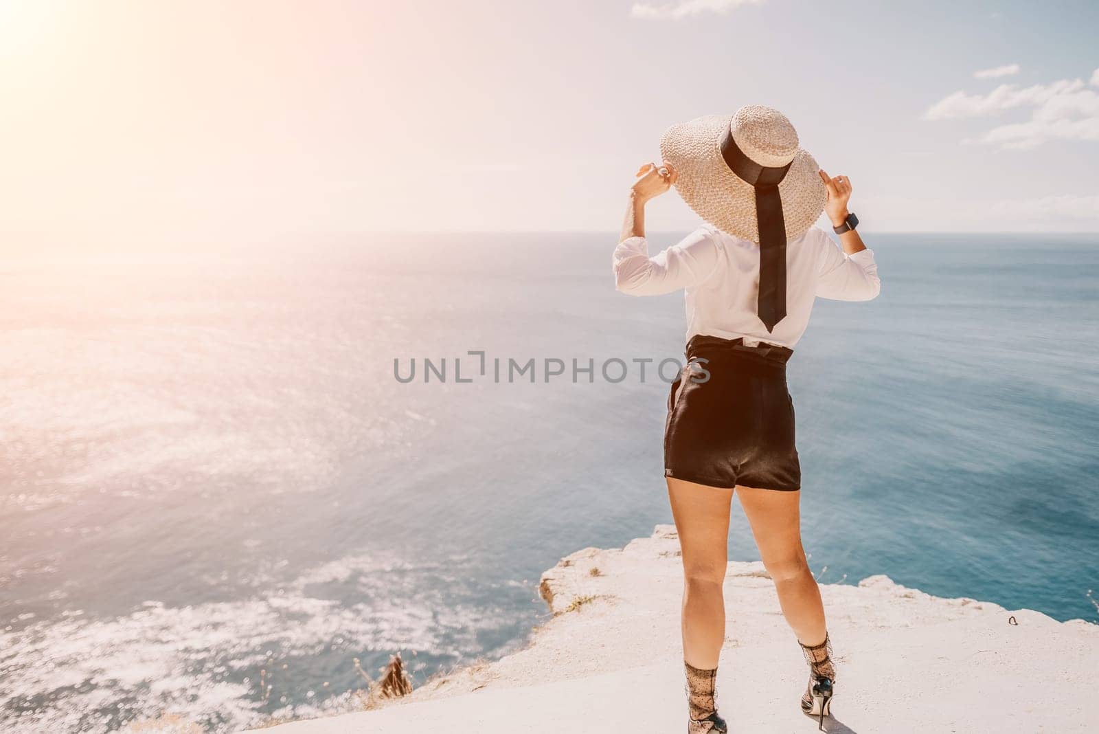 Woman sea hat. Business woman in yellow hat freelancer working over blue sea beach. Girl relieves stress from work. Freelance, digital nomad, travel and holidays concept by panophotograph