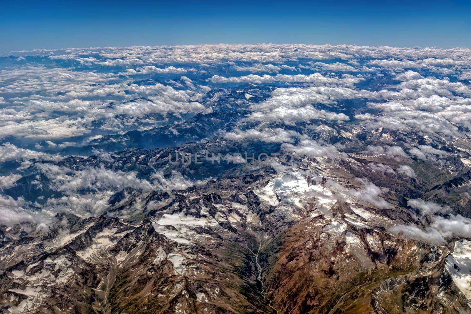 Alps mountains aerial view from airplane snow by AndreaIzzotti