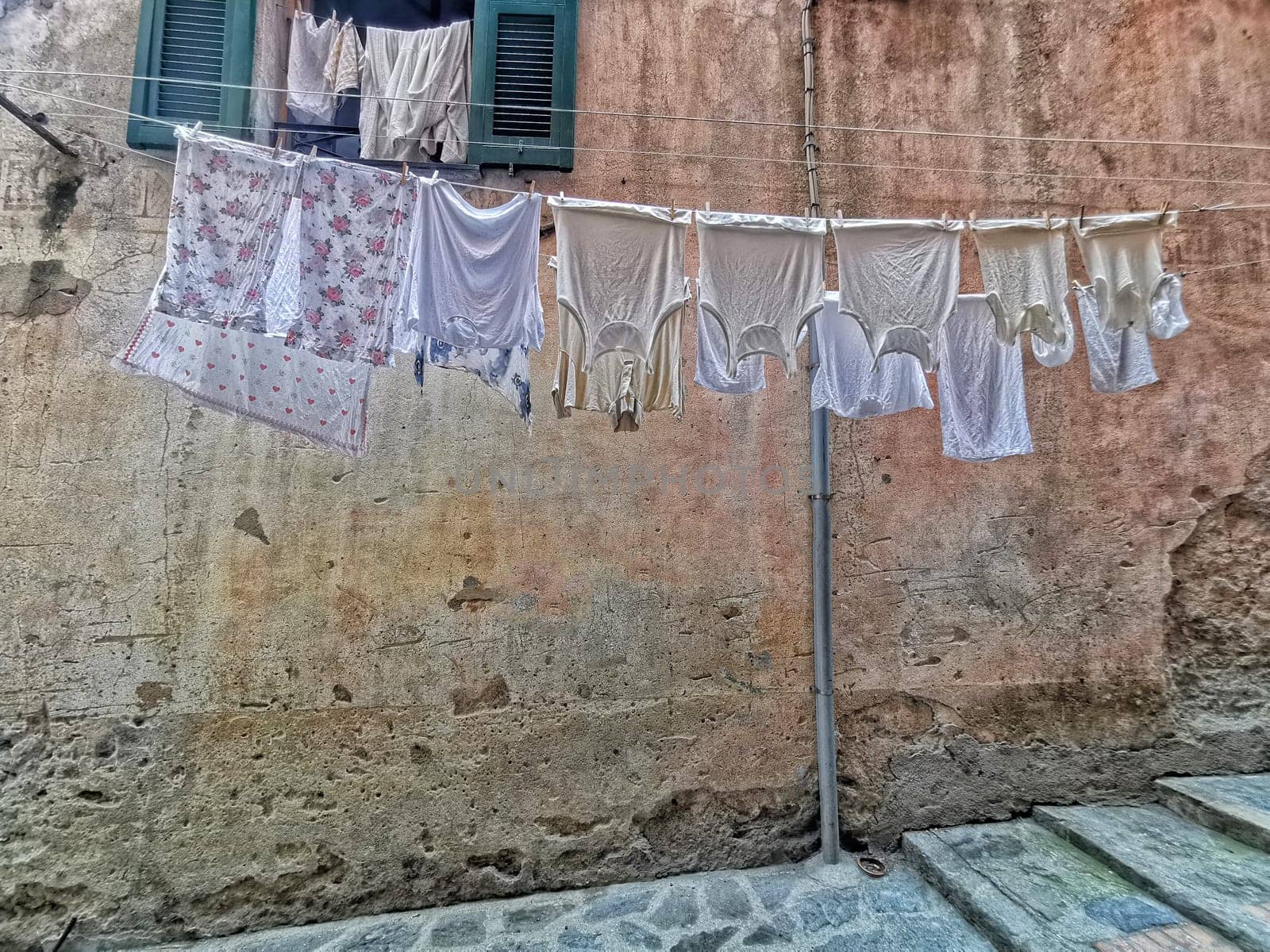 clothes hanging to dry in italian pictoresque village by AndreaIzzotti