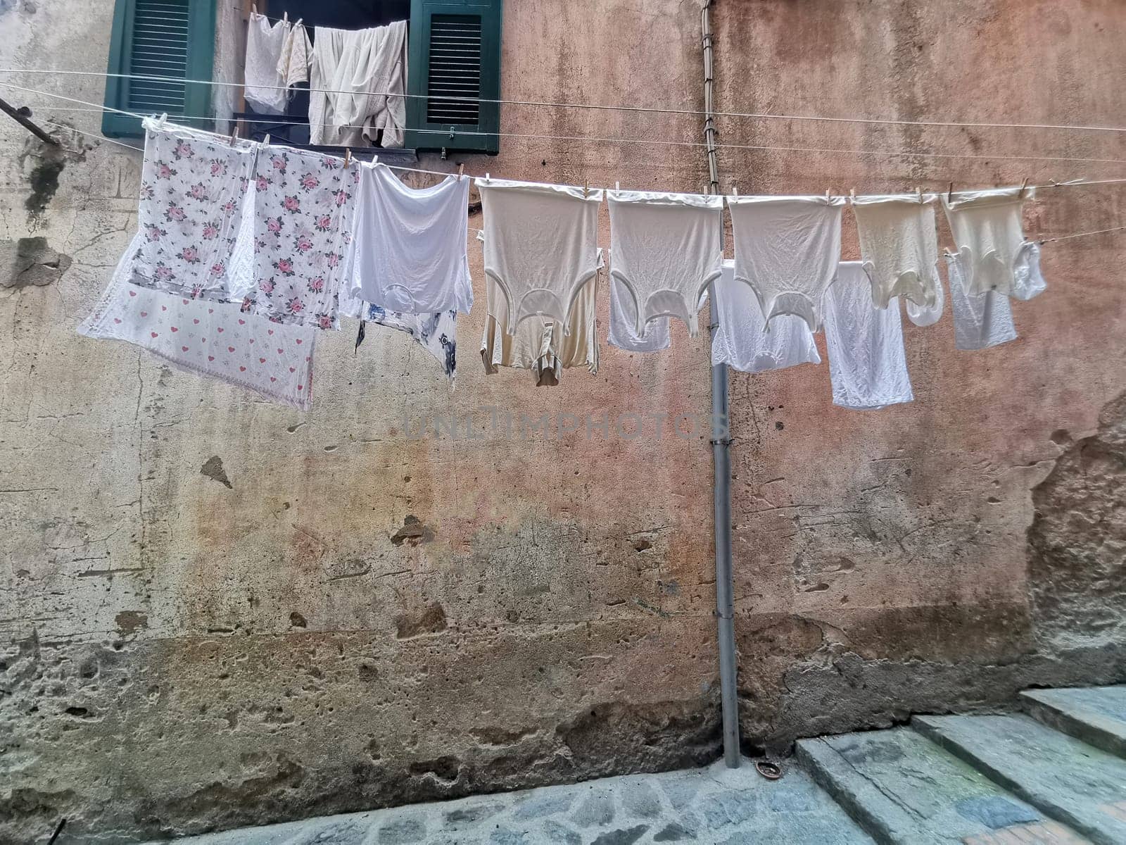 clothes hanging to dry in italian pictoresque village by AndreaIzzotti