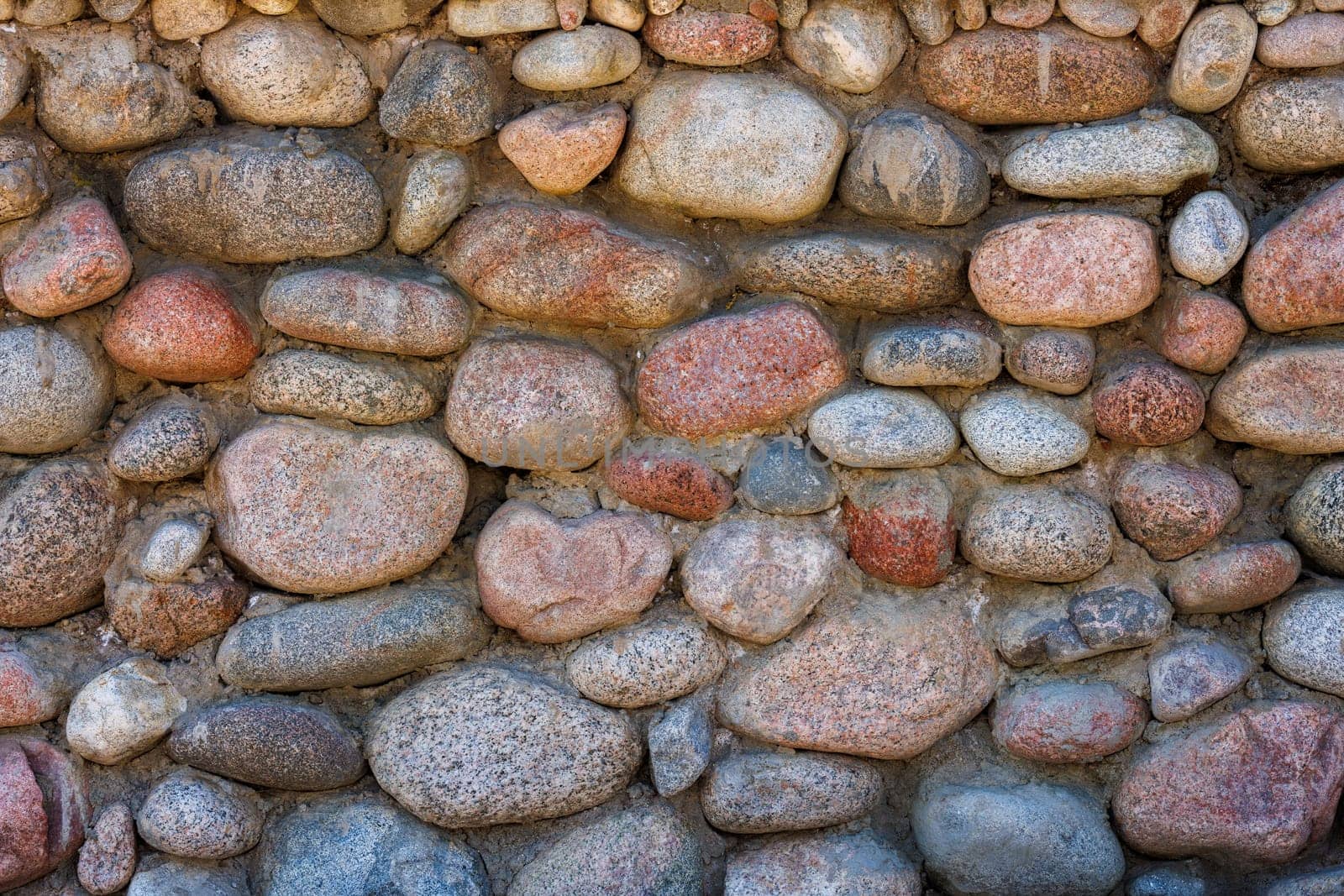 wall made of many colorful round stones, full-frame background and texture by z1b