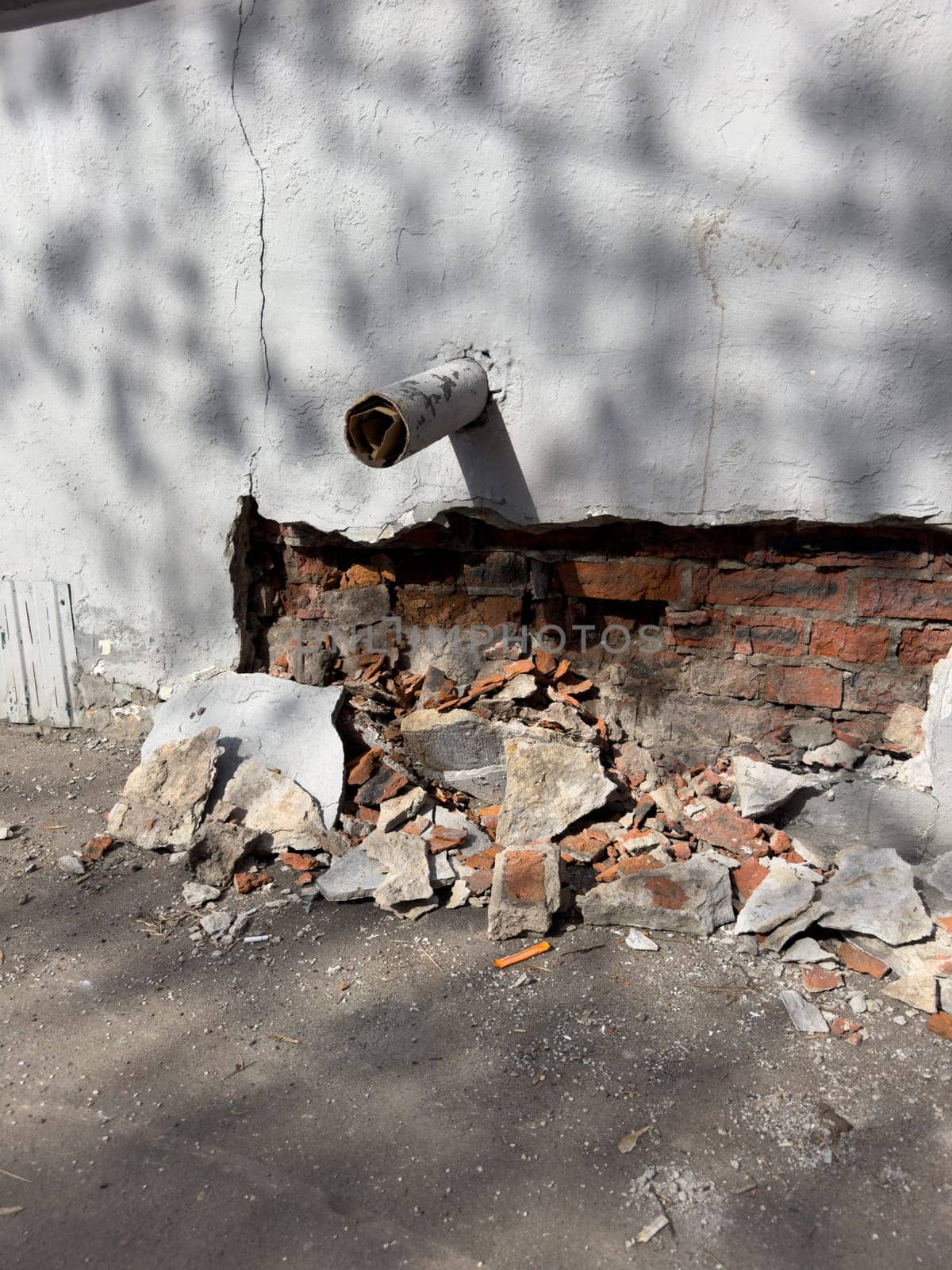 collapsed plaster on a red brick wall