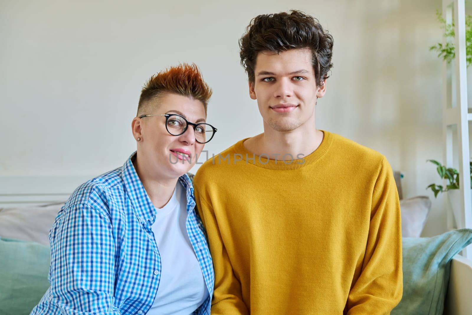 Portrait of a happy middle-aged mother and son 19-20 years old hugging together. Mother's day, family, parenthood, tenderness, parent and son, two generations concept