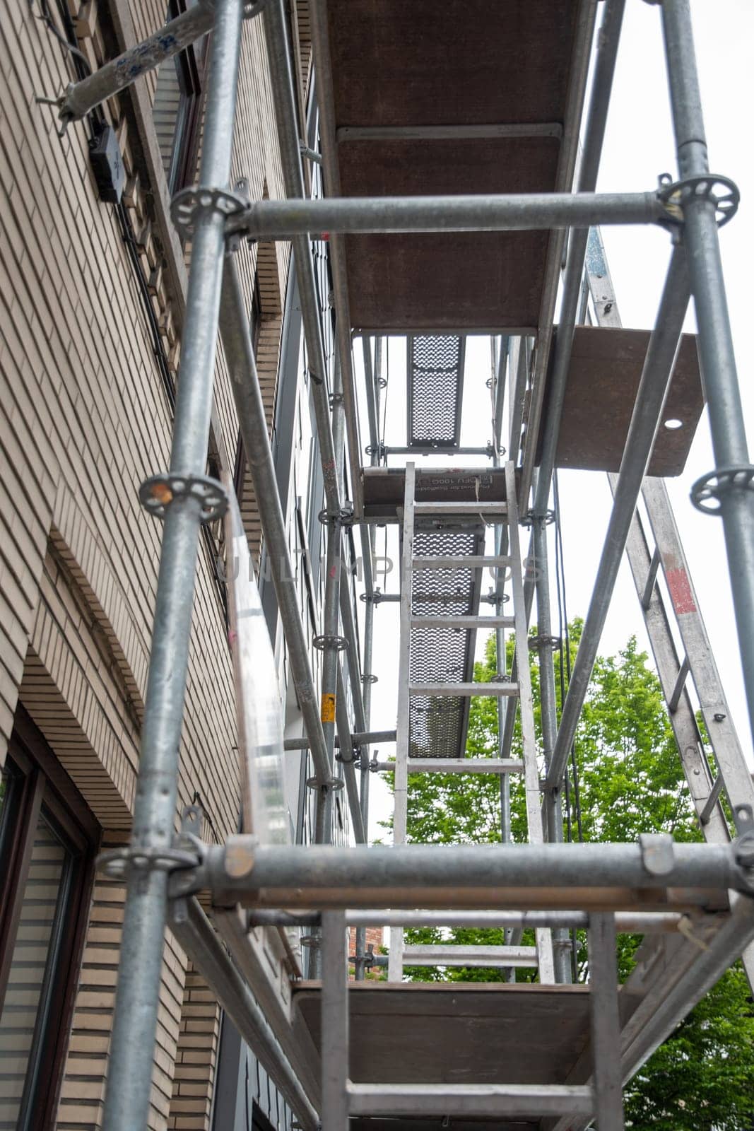 construction of steel scaffolding near building for renovation work,vertical scaffolding forms various grids,modern by KaterinaDalemans