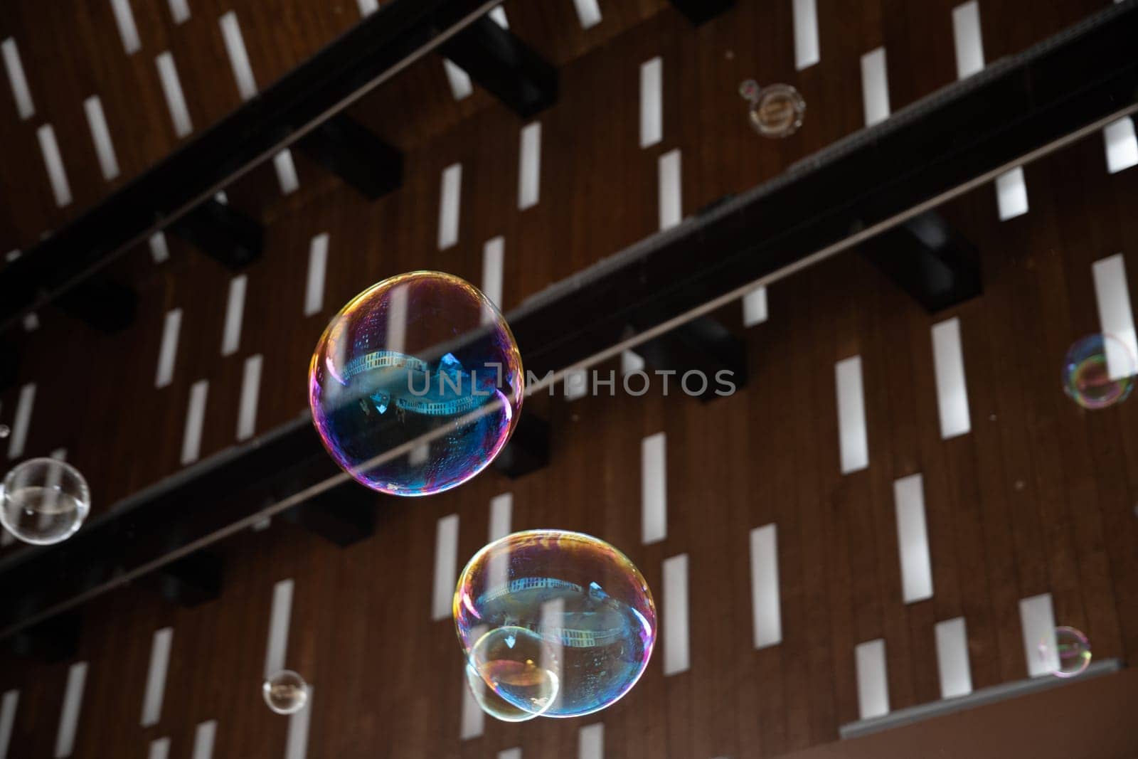 flying multicolored soap bubbles on a background of a roof with rectangular holes exotic background texture by KaterinaDalemans