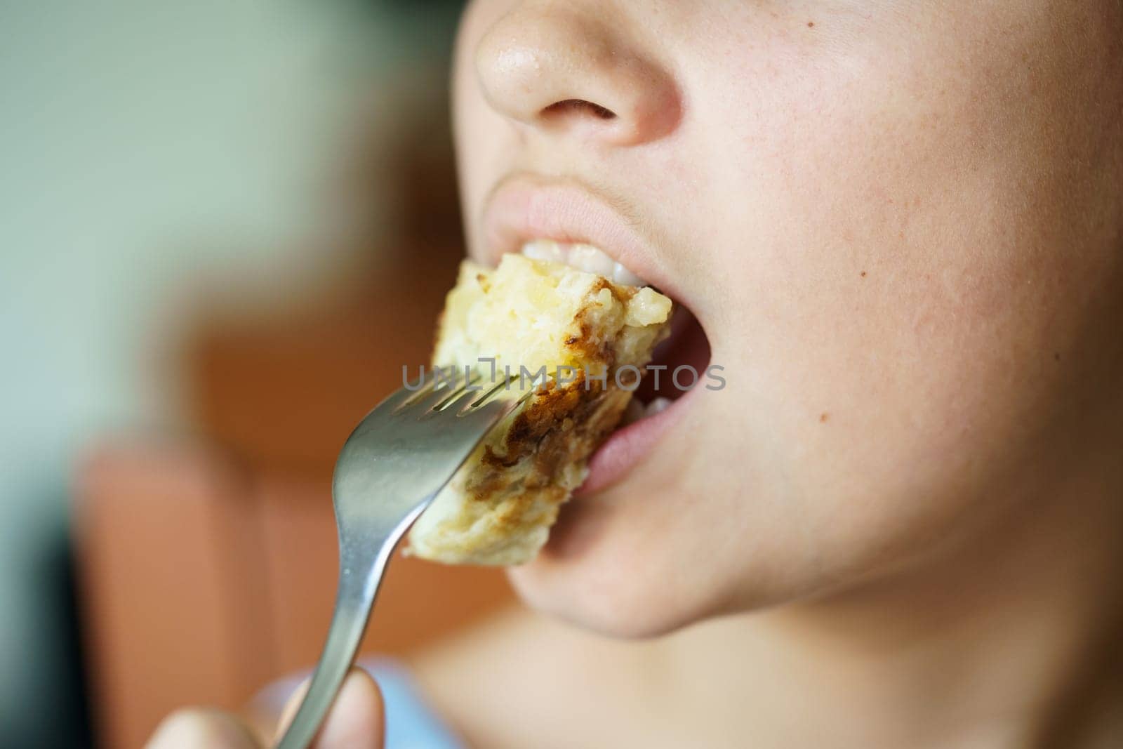 Crop anonymous girl eating fresh yummy Spanish potato omelette from fork by javiindy