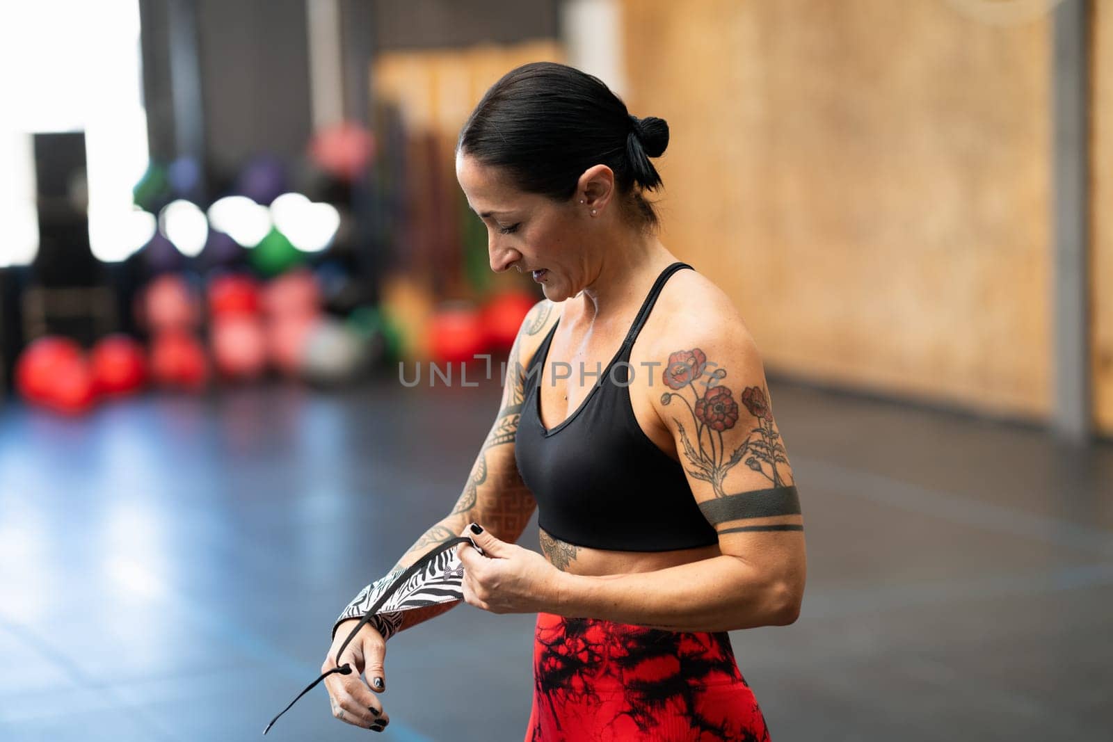 Woman protecting her wrists with wraps before training by javiindy