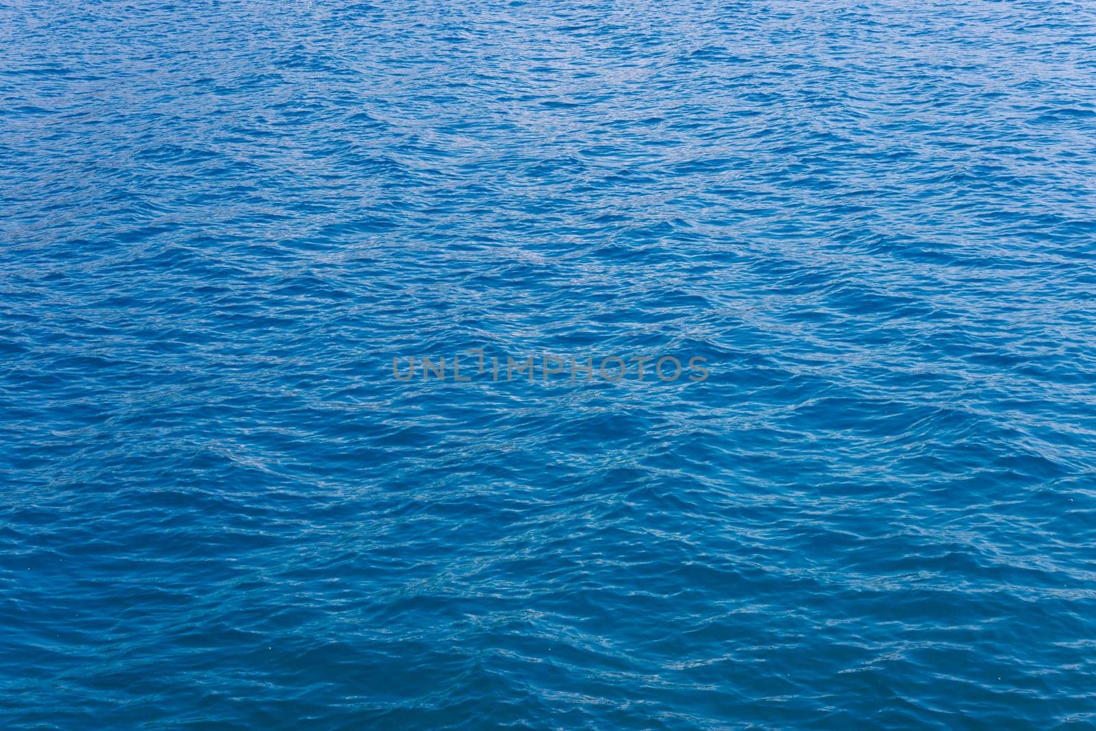 Closeup of calm electric blue waves on a liquid water surface by z1b