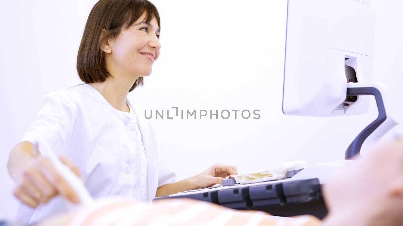 Cheerful female doctor smile during a ultrasound to pregnant woman